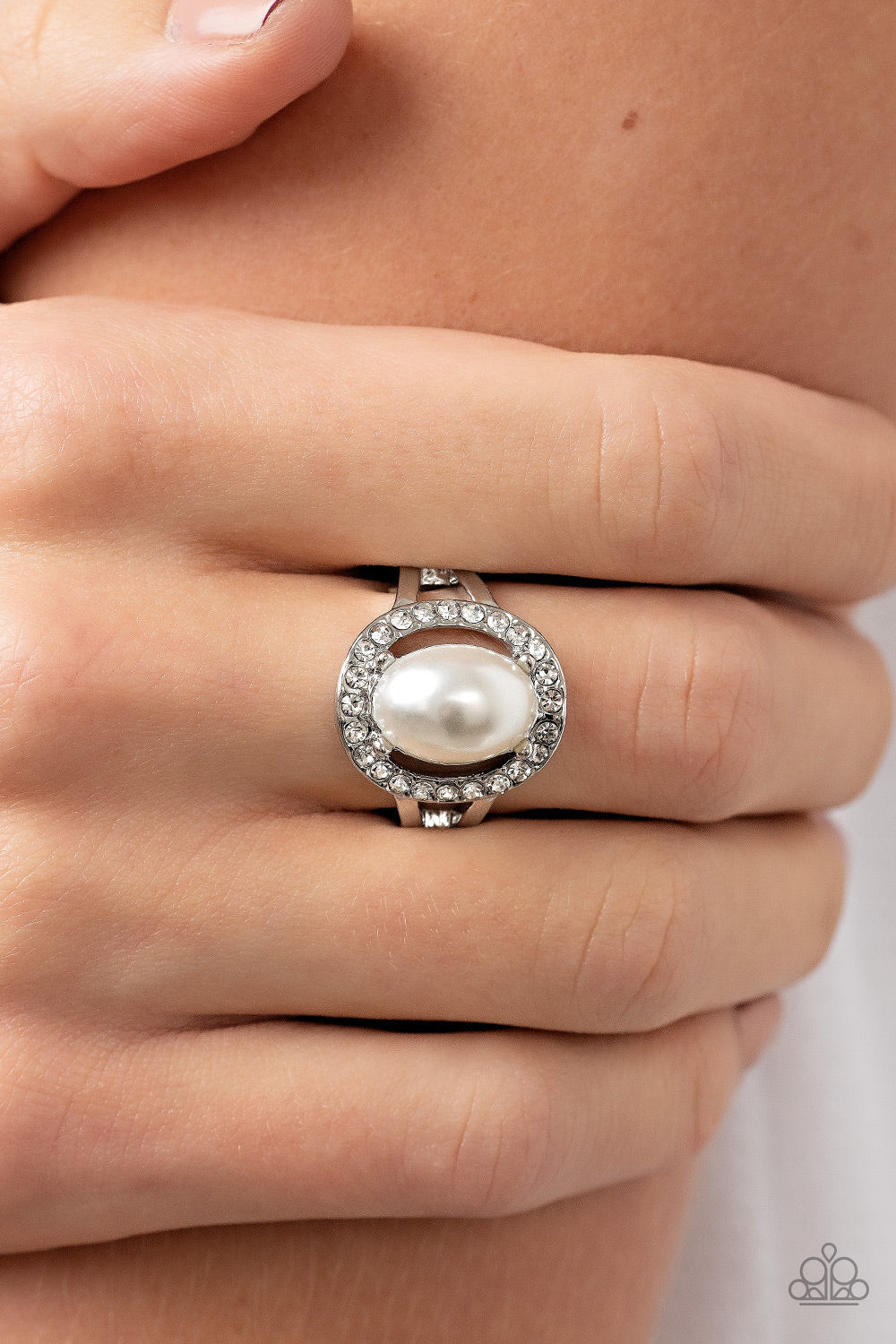 Paparazzi Accessories Seize the Shimmer - White An oval white pearl seemingly floats inside a glittery ring of white rhinestones atop layered bands of silver, resulting in a timeless centerpiece atop the finger. Features a dainty stretchy band for a flexi