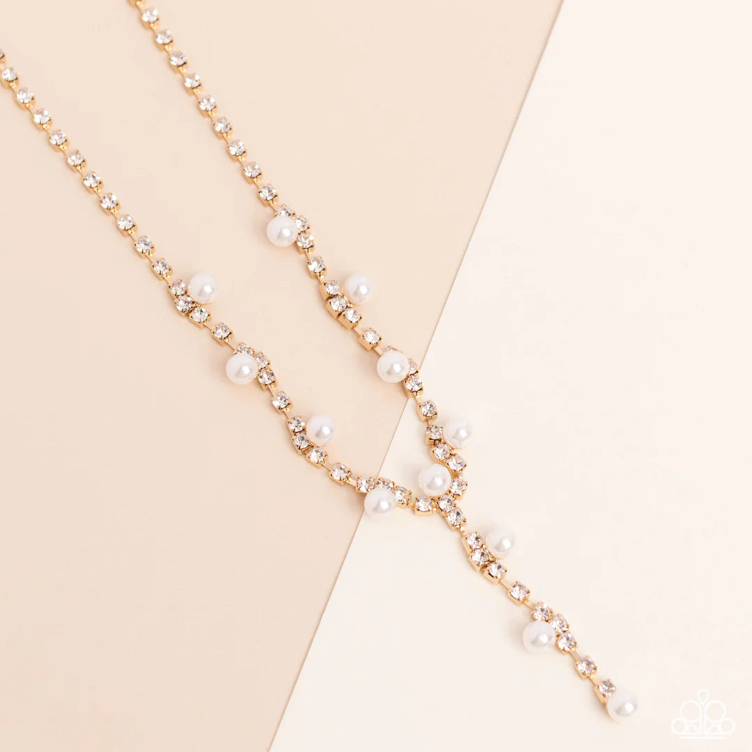 Paparazzi Accessories Upper Class - Gold Attached to a section of dainty gold links, white rhinestones, pressed into shiny gold box chain fittings swing down the neckline in a lariat-like manner for an effulgent glow. Sporadically infused along the box ch