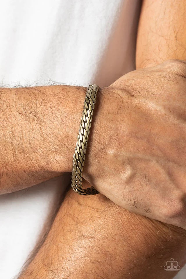Paparazzi Accessories Cargo Couture - Brass Brushed in a high-sheen finish, a thick, brass chain wraps around the wrist for an industrial look. Featured within the design, the chain seems to tightly stack on top of itself, emitting light from every angled