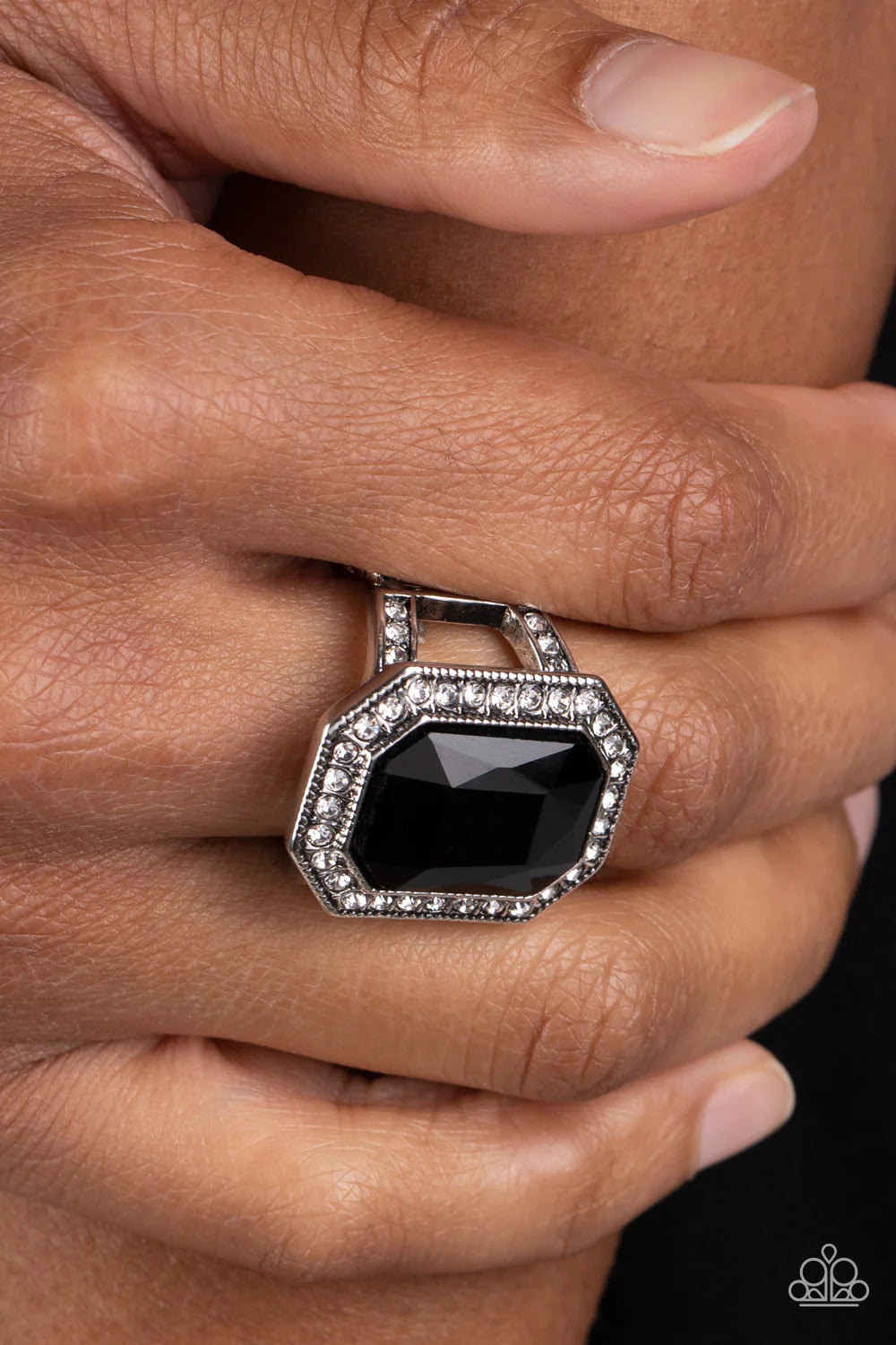 Paparazzi Accessories A Royal Welcome - Black An oversized, black, emerald-cut gem smolders inside a framework of studded silver texture and glitzy white rhinestones, resulting in an awe-inspiring statement piece that glamorously sits atop the finger. Fea