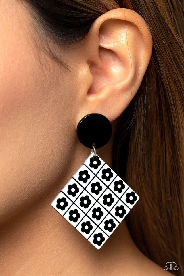 Paparazzi Accessories Vintage Vaudeville - Black Featuring a monochrome floral arrangement, black flowers are symmetrically arranged on a white square-cut acrylic frame for a high-fashion statement at the ear. The floral feature swings from a solid black