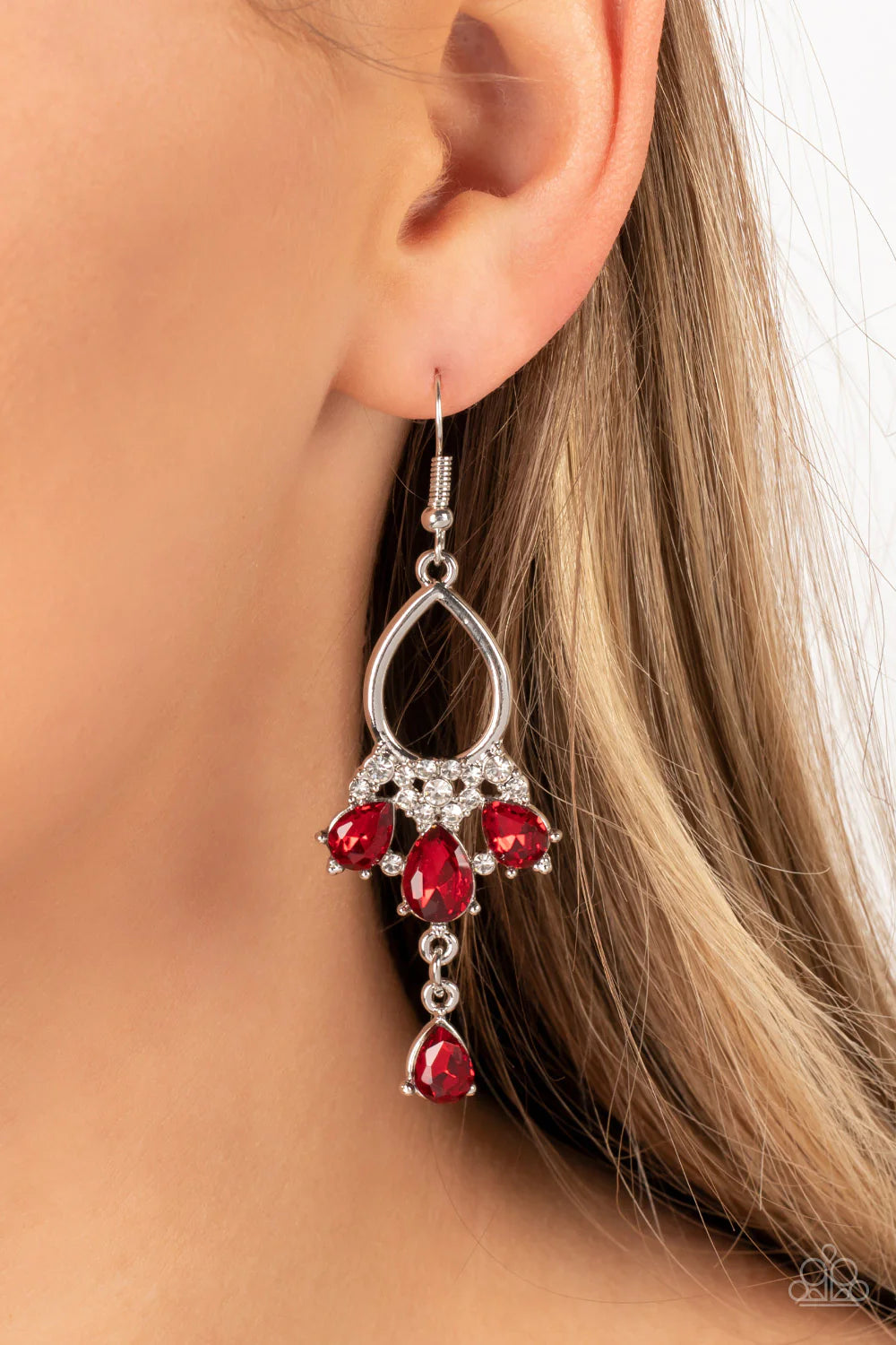 Paparazzi Accessories Coming in Clutch - Red A solitaire red teardrop rhinestone sways from the bottom of a fan of red rhinestone teardrops that flares out from a white rhinestone floral accent at the bottom of an airy silver frame, resulting in a modern