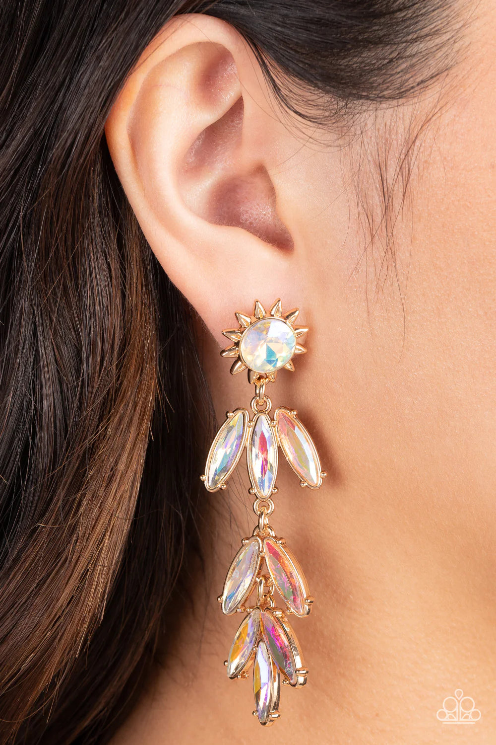 Paparazzi Accessories Space Age Sparkle - Gold A gold sunburst frame wraps around an iridescent gem as it gives way to an explosion of marquise-cut rhinestones in the same dreamy finish. The oblong frames swing dramatically from the ear, capturing and ref