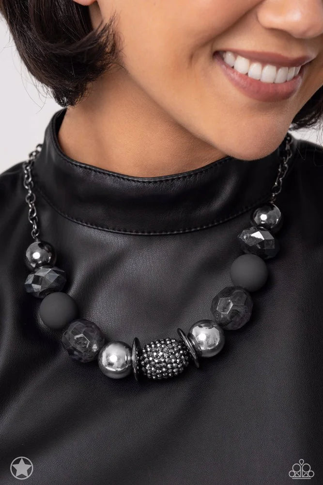Paparazzi Accessories A Warm Welcome - Black Sophisticated beads in shades of gunmetal and black with reflective faceted edges and varying glazed finishes are offset by two shiny silver beads. An oblong bead studded with gunmetal rhinestones adds a dramat