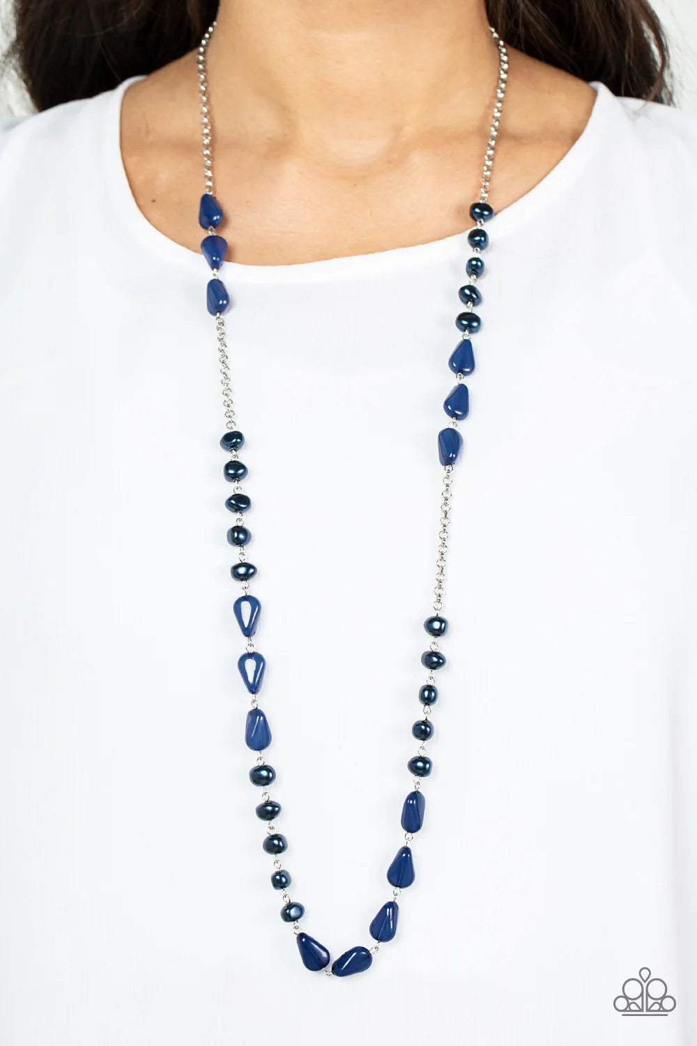 Paparazzi Accessories Shoreline Shimmer - Blue Enchanting sections of asymmetrical blue pearls and glassy blue teardrop beads alternate along an elegantly extended silver chain, creating a refined pop of color across the chest. Features an adjustable clas