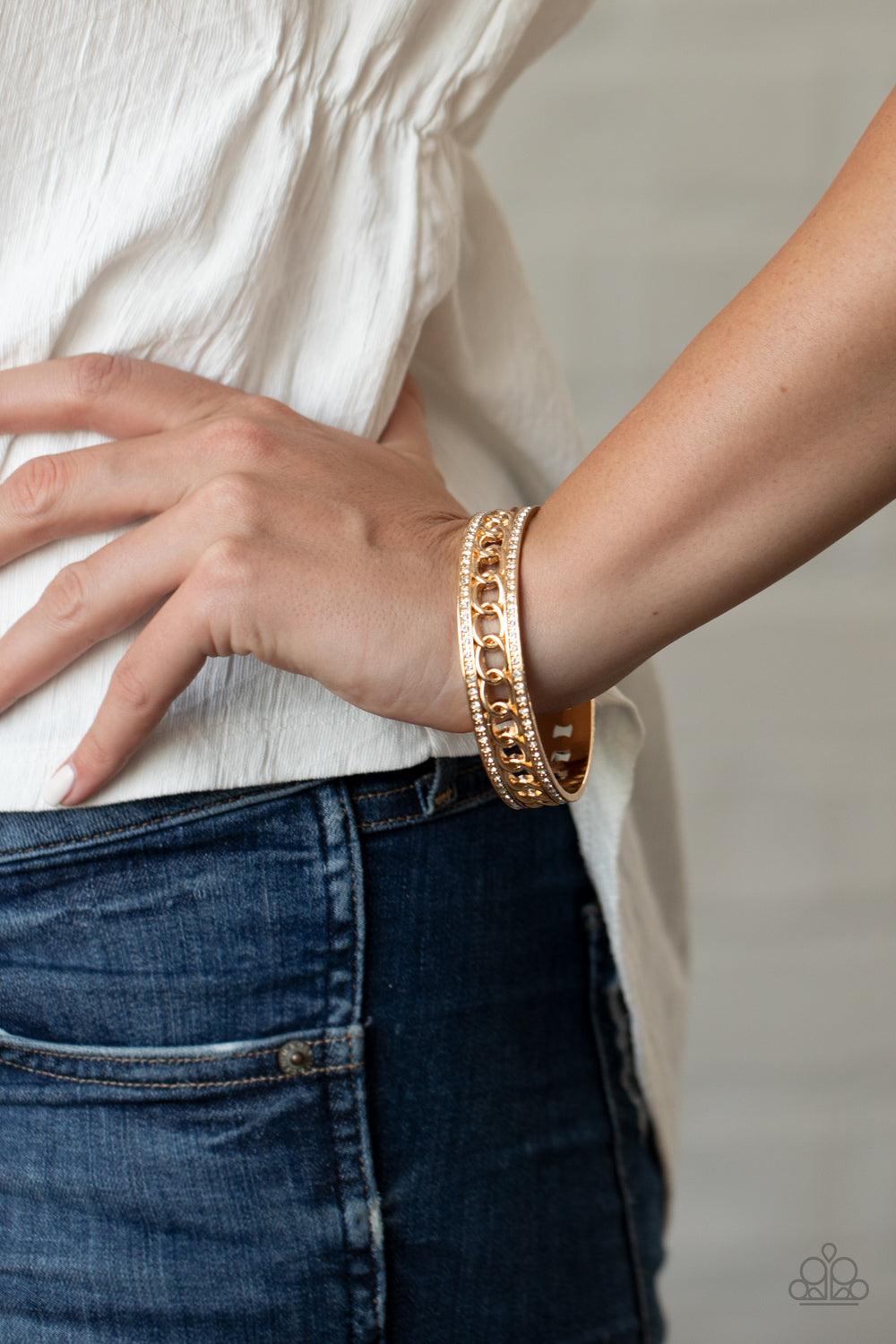 Paparazzi Accessories Couture Court - Gold Bordered in rows of blinding white rhinestones, a glistening strand of gold chain glamorously links around the wrist, coalescing into an unapologetically glittery bangle. Sold as one individual bracelet. Jewelry