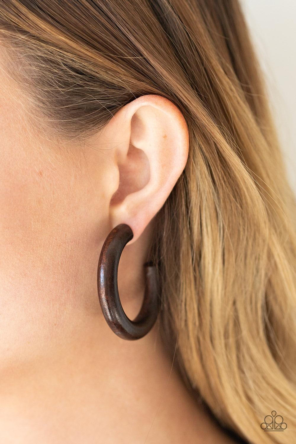 Paparazzi Accessories Woodsy Wonder - Brown Painted in a neutral brown finish, a thick wooden hoop curls around the ear for a flirtatiously earthy look. Earring attaches to a standard post fitting. Hoop measures approximately 2" in diameter. Sold as one p