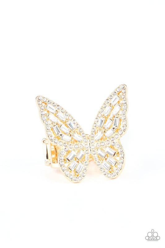 Paparazzi Accessories Flauntable Flutter - Gold Dainty white emerald style rhinestones are sprinkled across the golden wings of a butterfly that is encrusted in glassy white rhinestones for a dramatically dazzling finish. Features a stretchy band for a fl