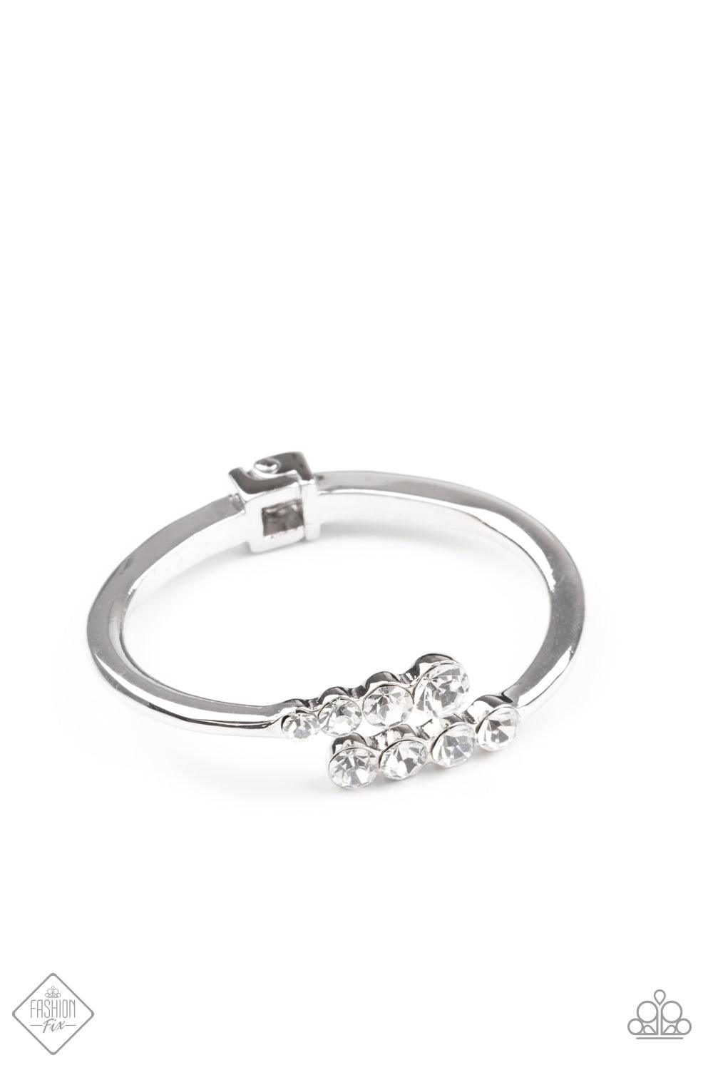 Paparazzi Accessories Defying Dazzle - White Attached to two thick silver bars, oversized rows of glittery white rhinestones delicately stack into a hypnotizing centerpiece around the wrist. Features a hinge closure. Sold as one individual bracelet. Jewel