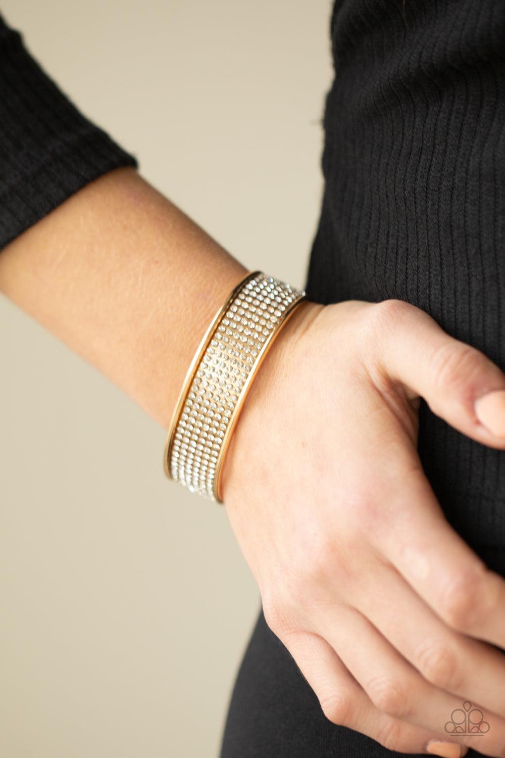 Paparazzi Accessories Cant Believe Your ICE - Gold Row after row of white rhinestones are encrusted along the front of a thick gold cuff, creating a blinding statement piece around the wrist. Sold as one individual bracelet. Jewelry