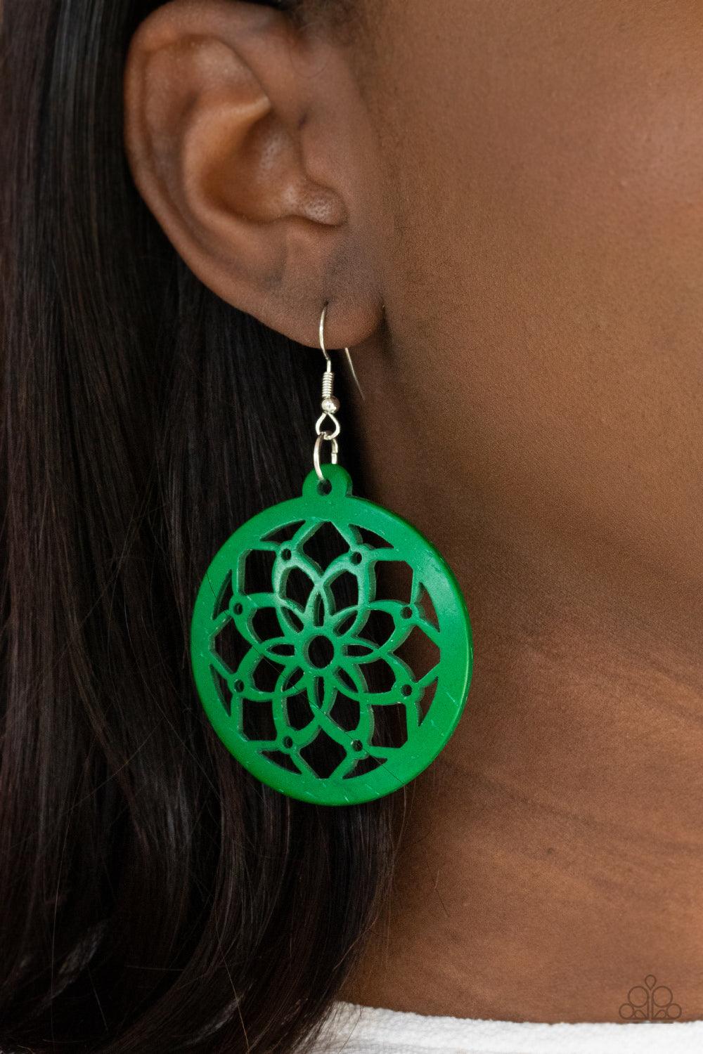 Paparazzi Accessories Mandala Meadow - Green The center of a green wooden frame has been cutout in an airy mandala-like pattern, creating a colorful flower. Earring attaches to a standard fishhook fitting. Sold as one pair of earrings. Jewelry