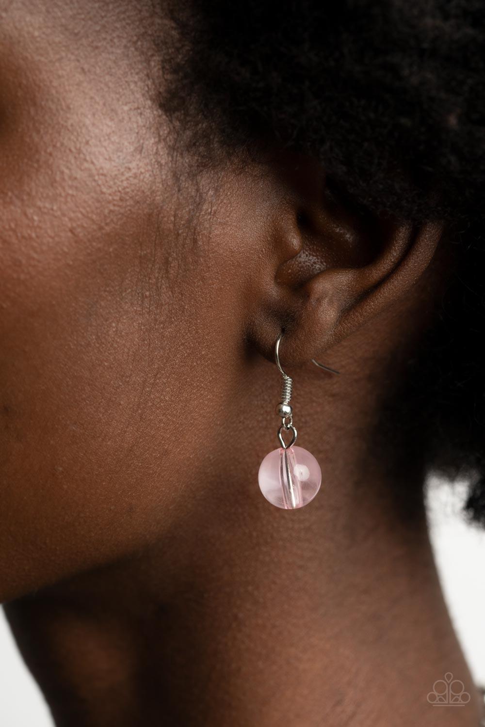 Paparazzi Accessories Staycation Stunner - Pink Featuring glassy, opaque, and solid finishes, an array of pink faux stone beads and dainty silver beads are threaded along an invisible wire below the collar, creating a colorful statement piece. Features an