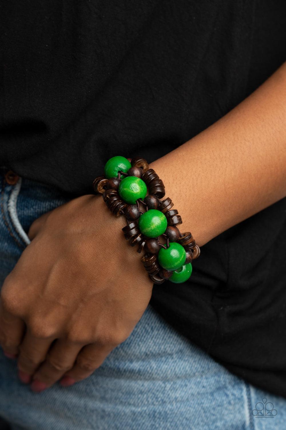 Paparazzi Accessories Tropical Temptations - Green Oversized green wooden beads, rustic brown wooden beads, and dainty wooden discs are ornately threaded along braided stretchy bands around the wrist, creating a summery centerpiece. Sold as one individual