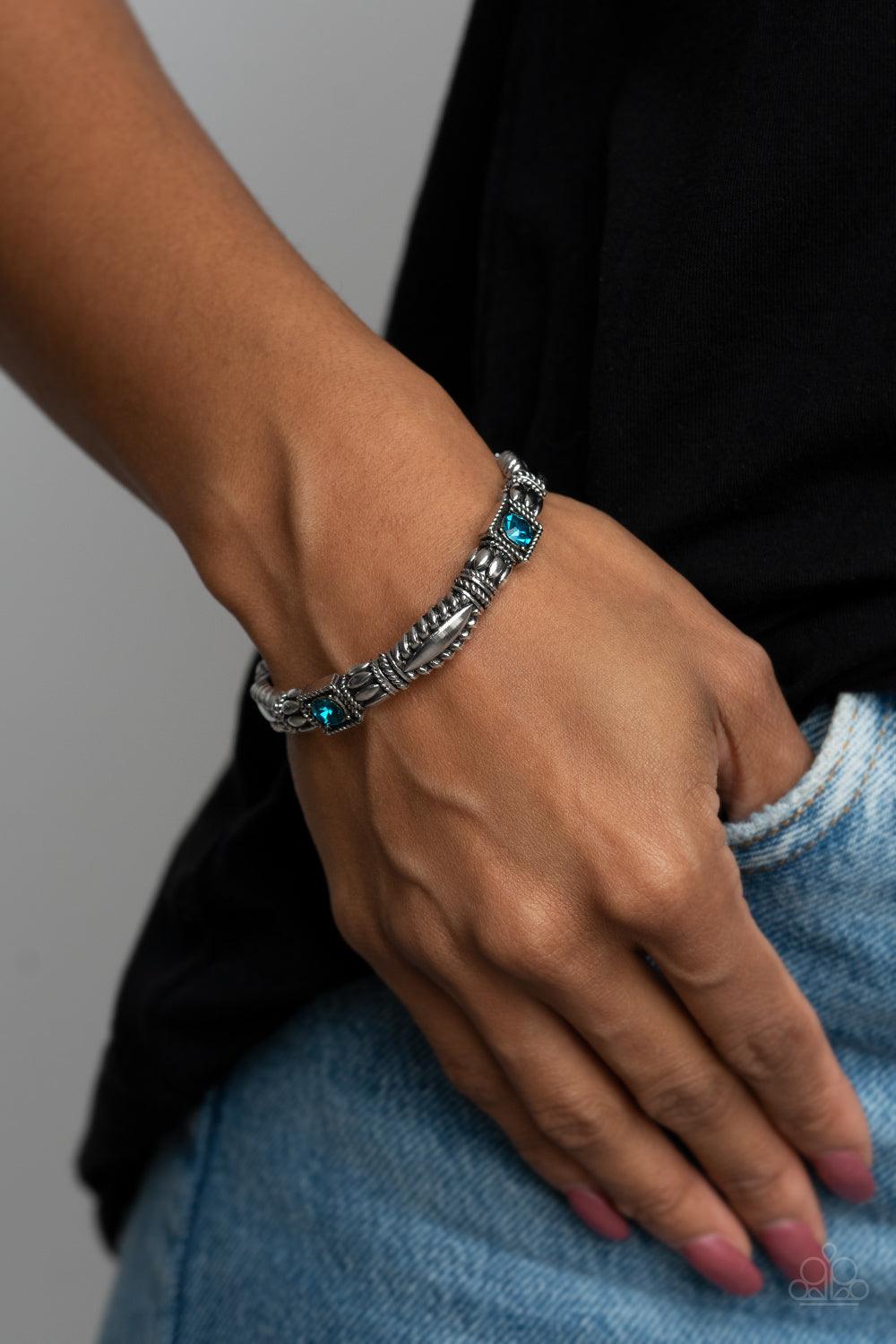 Paparazzi Accessories Get This GLOW On The Road - Blue Dotted with blue rhinestone centers, decorative silver frames are threaded along stretchy bands around the wrist, creating a colorful display. Sold as one individual bracelet. Jewelry
