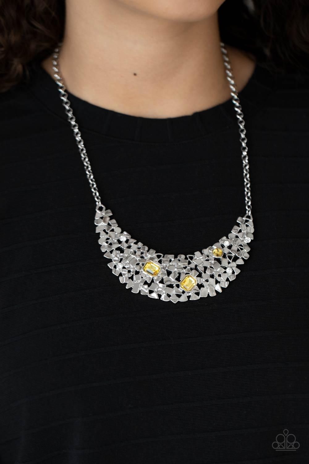 Paparazzi Accessories Fabulously Fragmented - Yellow Sporadically dotted in mismatched yellow and white rhinestones, a smattering of fragmented silver frames coalesce into a bold half moon below the collar for an edgy fashion. Features an adjustable clasp