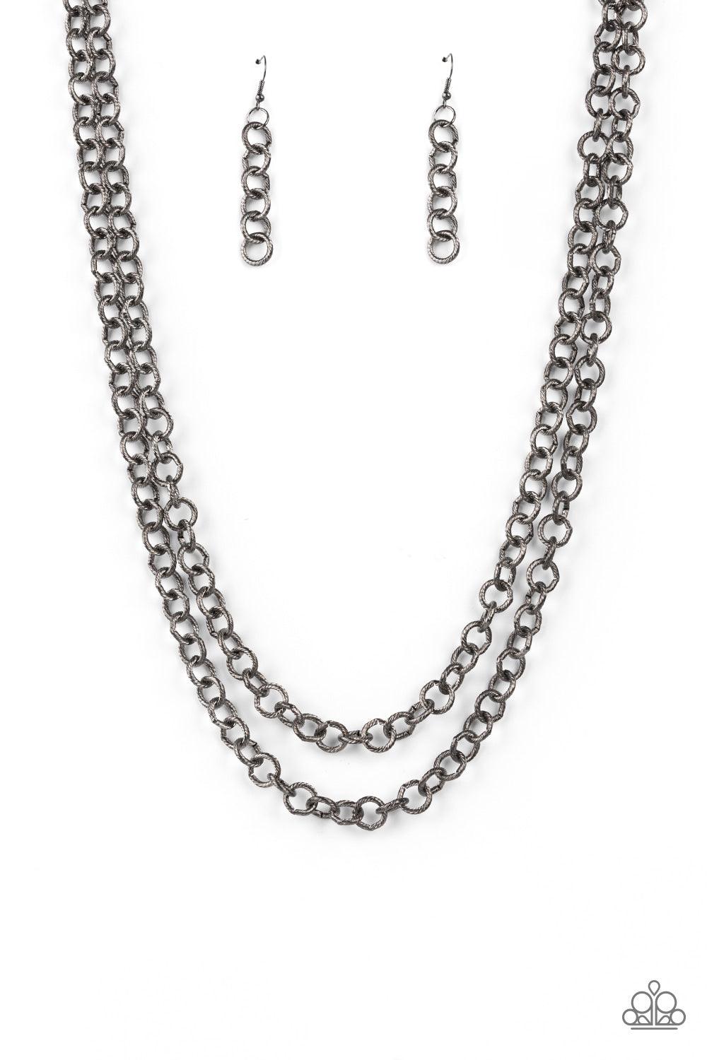 Paparazzi Accessories Grunge Goals - Black A seemingly infinite collection of textured gunmetal links connect into two dramatic rows across the chest, creating an intense industrial display. Features an adjustable clasp closure. Sold as one individual nec
