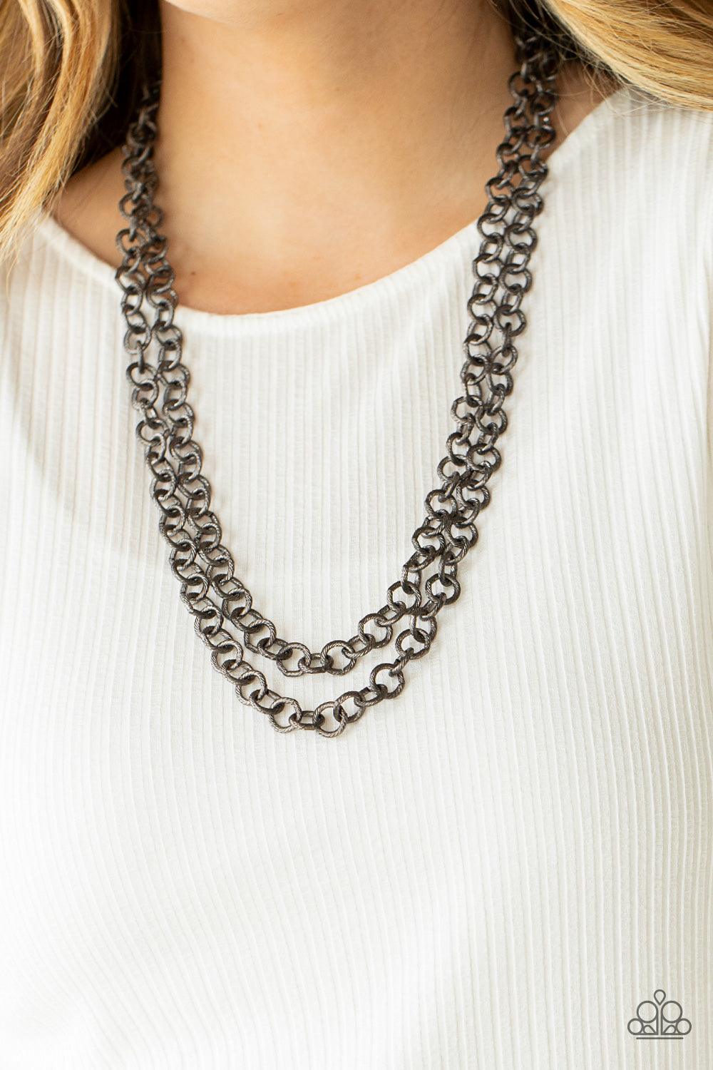 Paparazzi Accessories Grunge Goals - Black A seemingly infinite collection of textured gunmetal links connect into two dramatic rows across the chest, creating an intense industrial display. Features an adjustable clasp closure. Sold as one individual nec