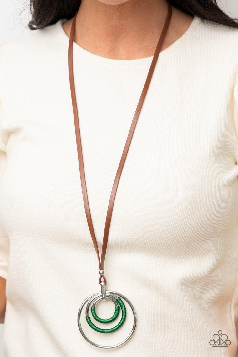Paparazzi Accessories Hypnotic Happenings - Green An impressive set of thick silver hoops is held together in concentric fashion by a strong silver fitting. Boldly wrapped bright green thread accents two hoops as the hefty pendant suspends from a lengthen