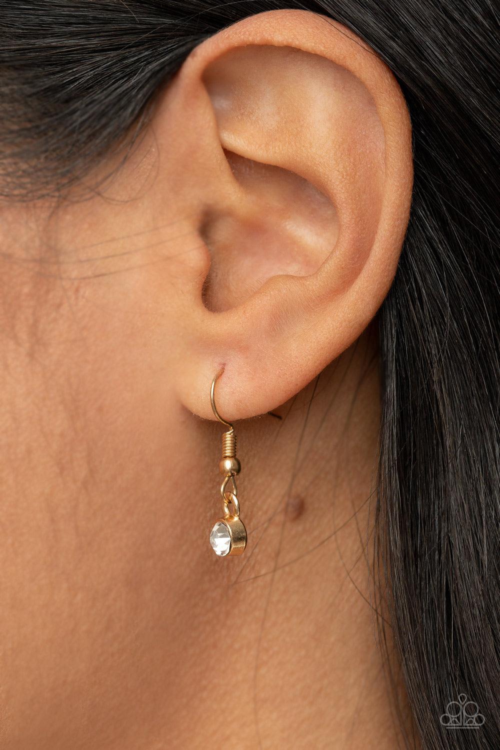 Paparazzi Accessories Grandma Glow - Gold A gold heart engraved with the word "Grandma," dangles from two smaller hearts at the bottom of a lengthened shimmery gold chain. The first heart is accented with sparkly white rhinestones creating an affectionate