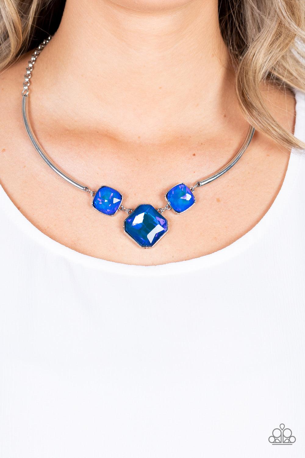 Paparazzi Accessories Divine IRIDESCENCE - Blue Featuring a subtle UV shimmer, an oversized collection of radiant cut blue gems delicately link at the bottom of two curved silver rods. Attached to shiny silver chains, the glamorously glitzy display sparkl