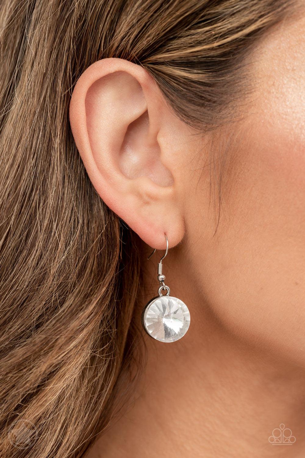 Paparazzi Accessories Spotlight Stunner - White Encased in sleek silver fittings, dramatically oversized white rhinestones delicately link into twinkly tassels that taper off into a jaw-dropping fringe below the collar. Features an adjustable clasp closur