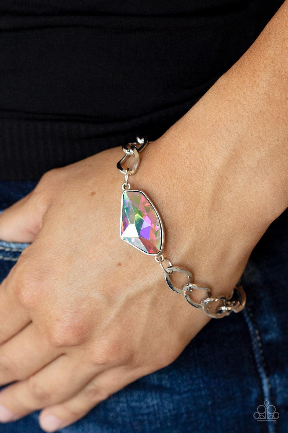 Paparazzi Accessories Galactic Grunge - Multi Featuring a UV shimmer, a raw cut multi gem is pressed into a sleek silver frame that attaches to a bold silver chain around the wrist for a glitzy grunge fashion. Features an adjustable clasp closure. Sold as