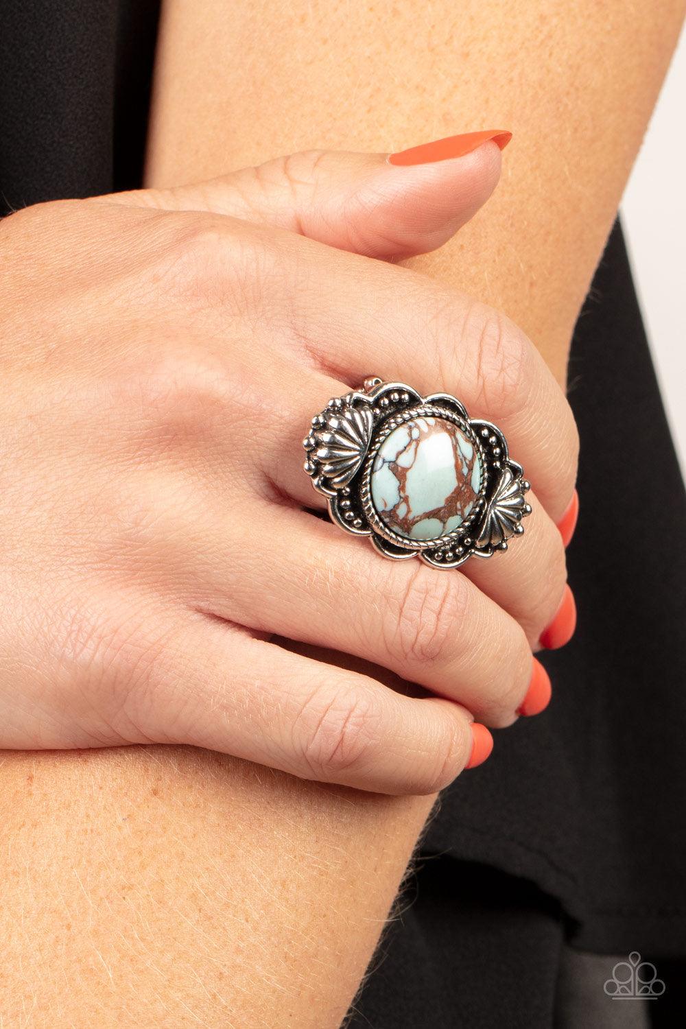 Paparazzi Accessories Atlantis Adventure - Blue Adorned in silver seashells and dainty silver studs, the center of a scalloped silver frame is dotted with an oversized blue stone for an artisan inspired finish. Features a stretchy band for a flexible fit.
