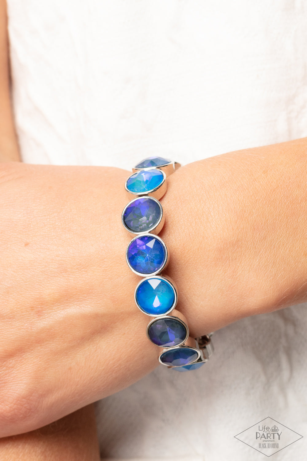 Paparazzi Accessories Radiant on Repeat - Blue Encased in sleek silver fittings, a sparkly series of opalescent blue rhinestones are threaded along stretchy bands around the wrist for a radiant finish. Sold as one individual bracelet. Jewelry