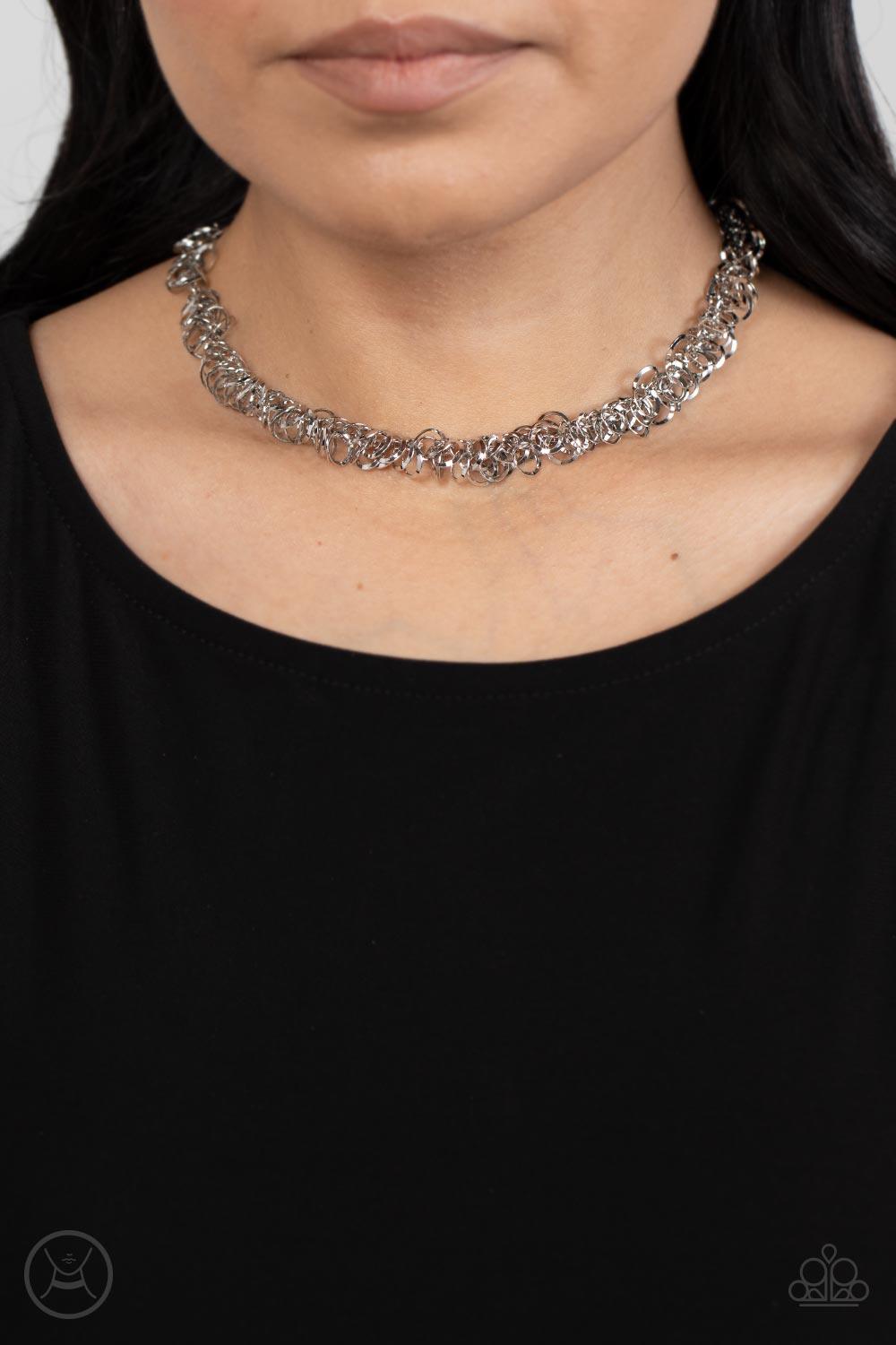 Paparazzi Accessories Cause a Commotion - Silver A shiny series of flat and beveled silver hoops delicately cluster along a dainty silver chain around the neck, creating a tinkling fringe. Features an adjustable clasp closure. Sold as one individual choke