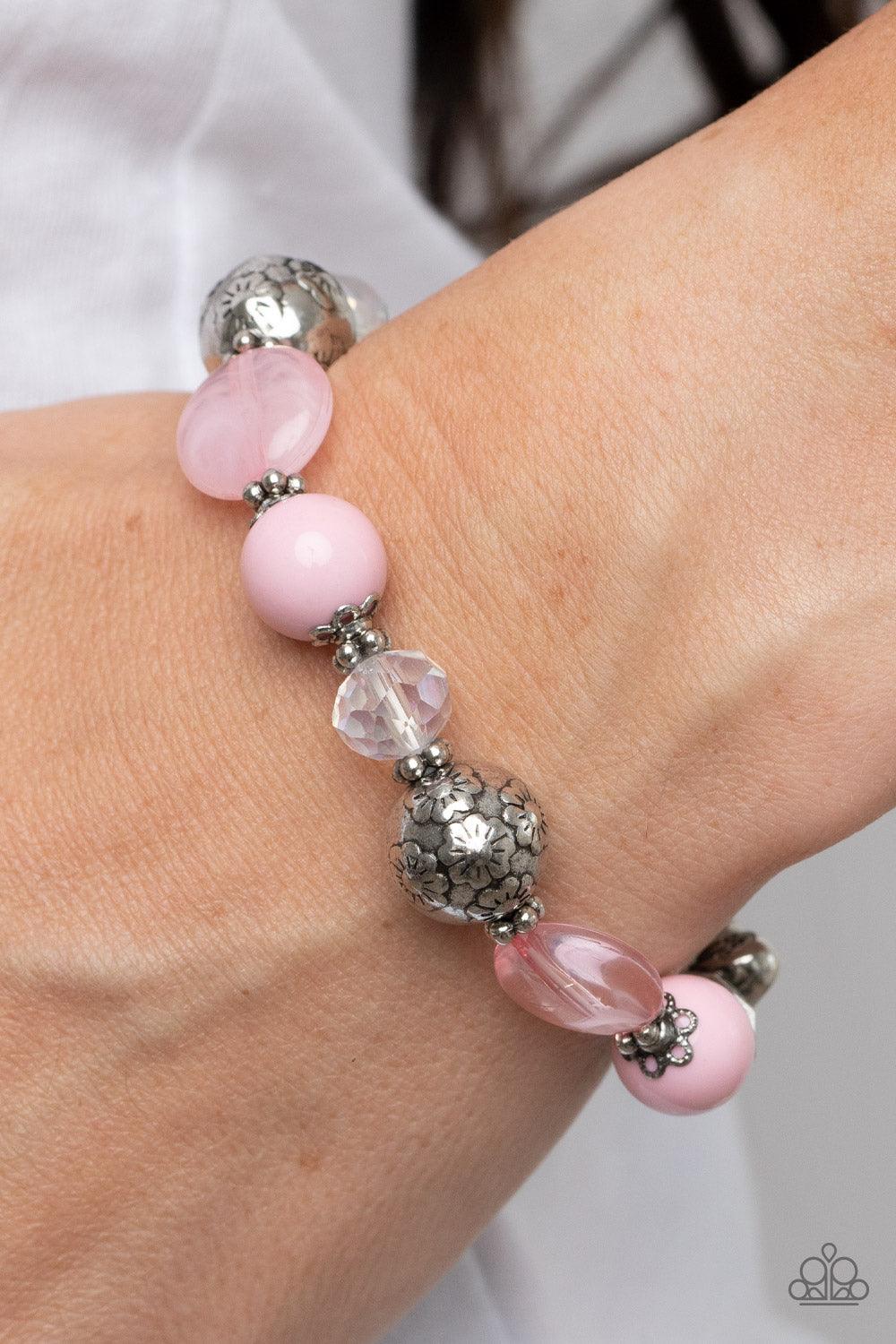 Paparazzi Accessories Pretty Persuasion - Pink An enchanting assortment of silver floral beads and studded silver rings join an opaque, glassy, and iridescent assortment of pink and white beads along a stretchy band around the wrist for a whimsical pop of