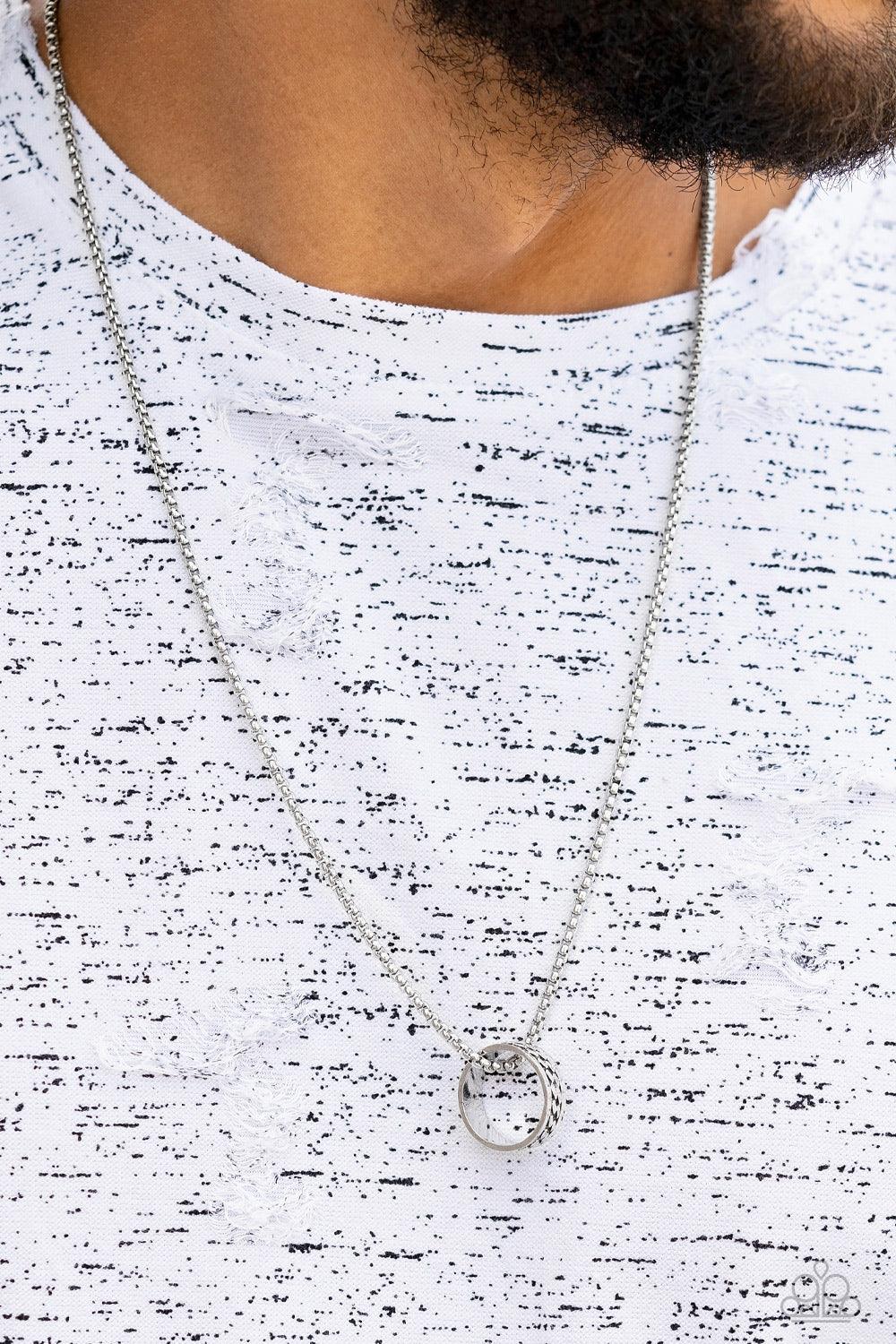 Paparazzi Accessories Emotion Potion - Silver Embossed in a band of zigzagging texture, an antiqued silver ring glides along a strand of silver box chain across the chest in a rustic fashion. Features an adjustable clasp closure. Sold as one individual ne