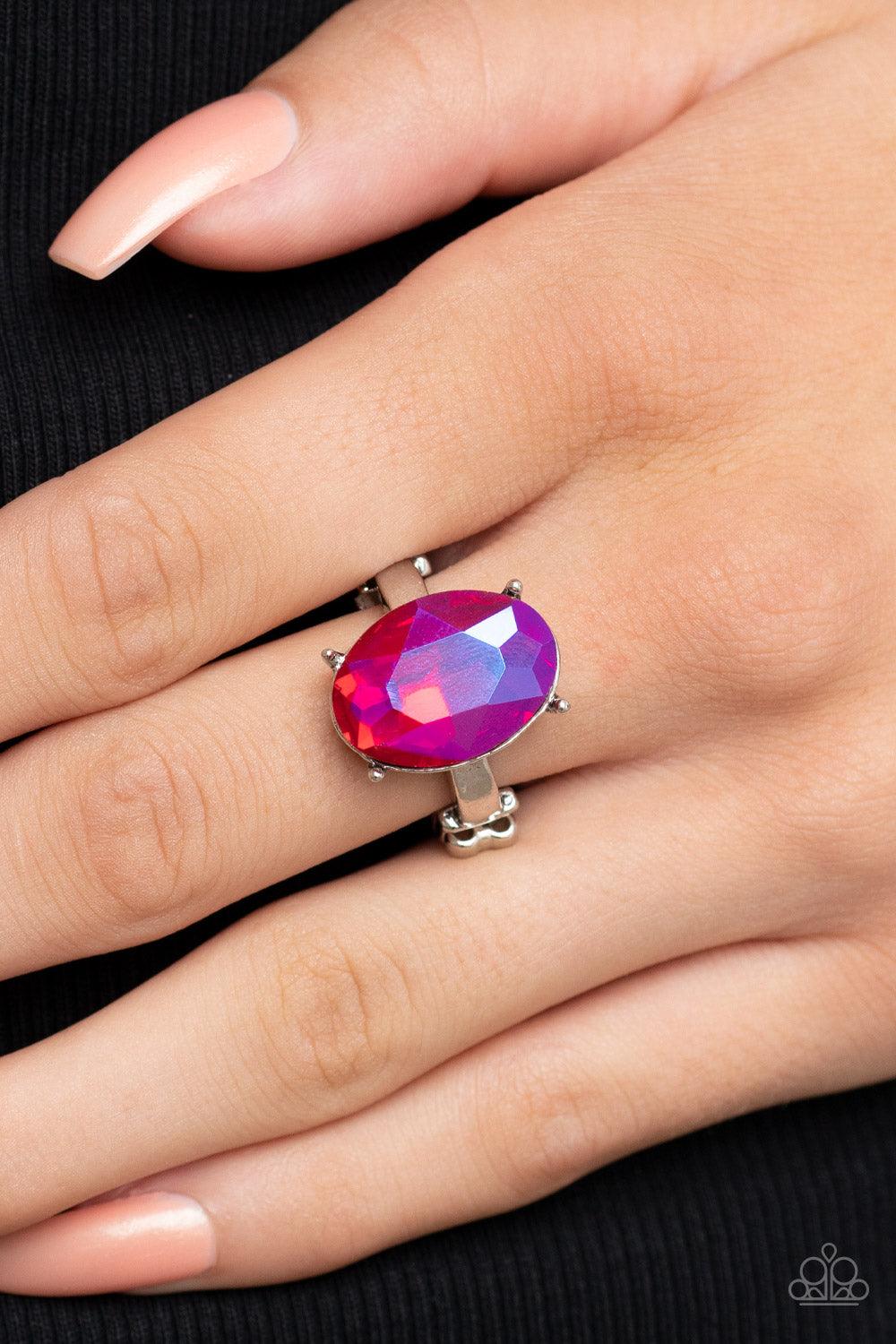 Paparazzi Accessories Updated Dazzle - Pink A stunning faceted iridescent pink gem, set in edgy pronged fittings, creates a glamorous show-stopping centerpiece atop sleek silver bands. Features a dainty stretchy band for a flexible fit. Sold as one indivi