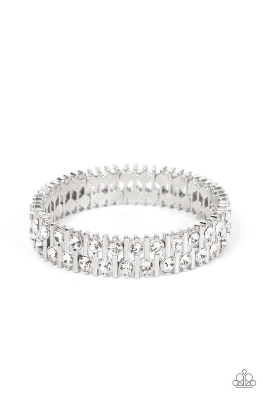 Paparazzi Accessories Generational Glimmer - White Attached to silver bars, a staggered display of solitaire white rhinestones alternates along a stretchy band around the wrist for an unexpected pop of shimmer around the wrist. Sold as one individual brac
