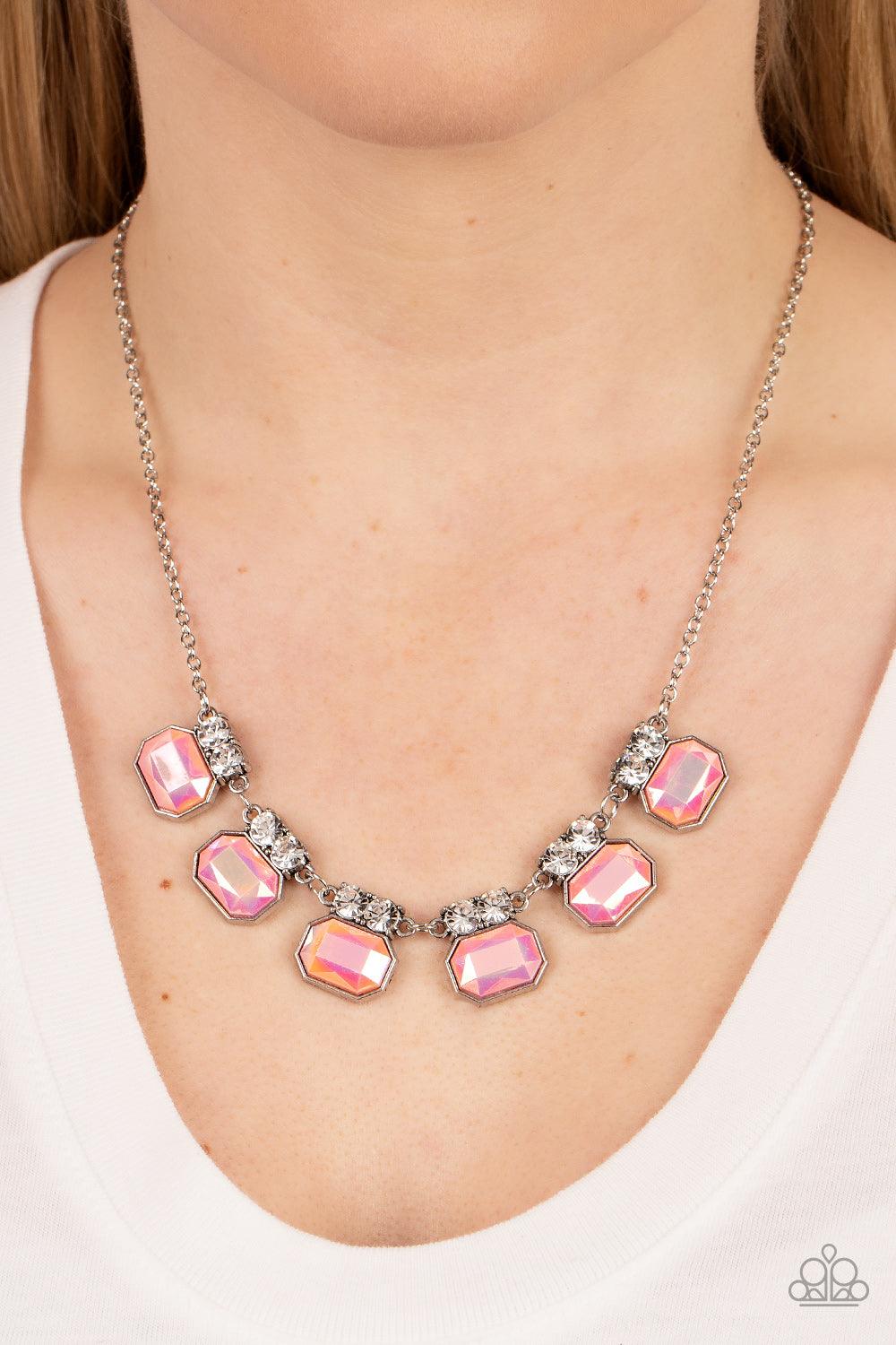 Paparazzi Accessories Interstellar Inspiration - Pink Featuring an iridescent UV finish, glitzy pink rhinestones are crowned in pairs of glassy white rhinestones as they delicately link below the collar for an out-of-this-world sparkle. Features an adjust