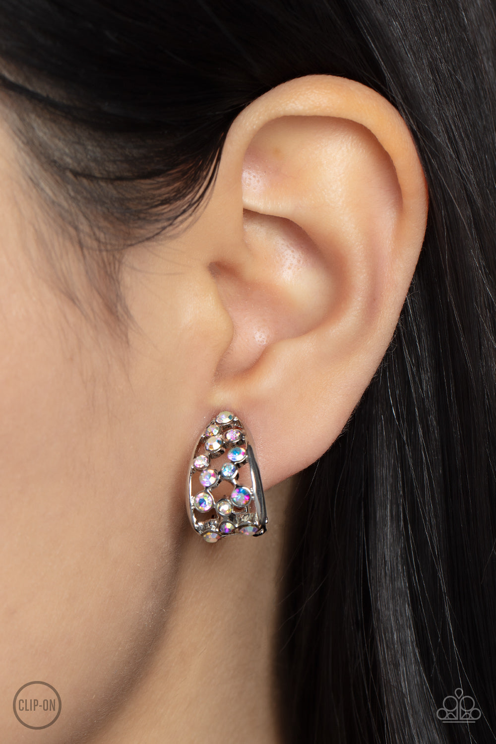 Paparazzi Accessories Extra Effervescent - Multi *Clip-On A collection of dainty iridescent rhinestones tumbles down the airy center of a curved silver frame, resulting in a stellar effervescence. Earring attaches to a standard clip-on fitting. Sold as on
