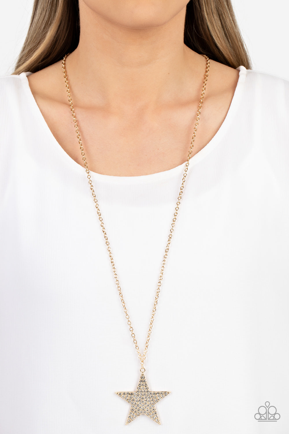 Paparazzi Accessories Rock Star Sparkle - Gold The front of an oversized gold star is encrusted in blinding white rhinestones, resulting in a stellar pendant at the bottom of a lengthened gold chain. Features an adjustable clasp closure. Sold as one indiv