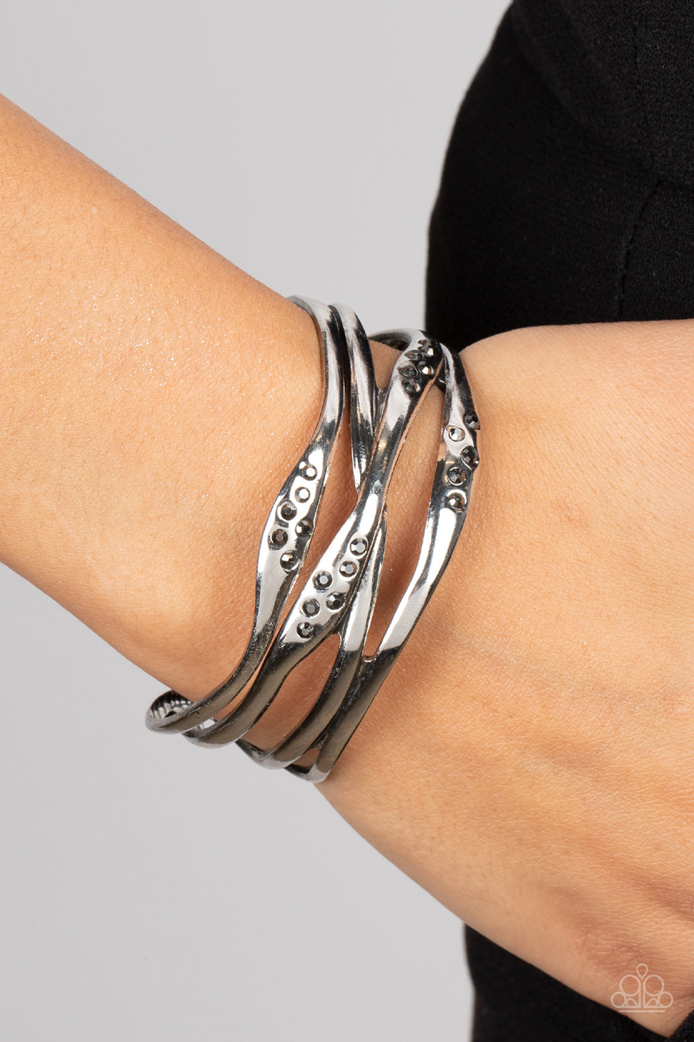 Paparazzi Accessories Line It Up - Silver Dusted in sections of dainty hematite rhinestones, asymmetrical silver bars boldly crisscross the wrist into a gritty yet glamorous cuff. Sold as one individual bracelet. Jewelry