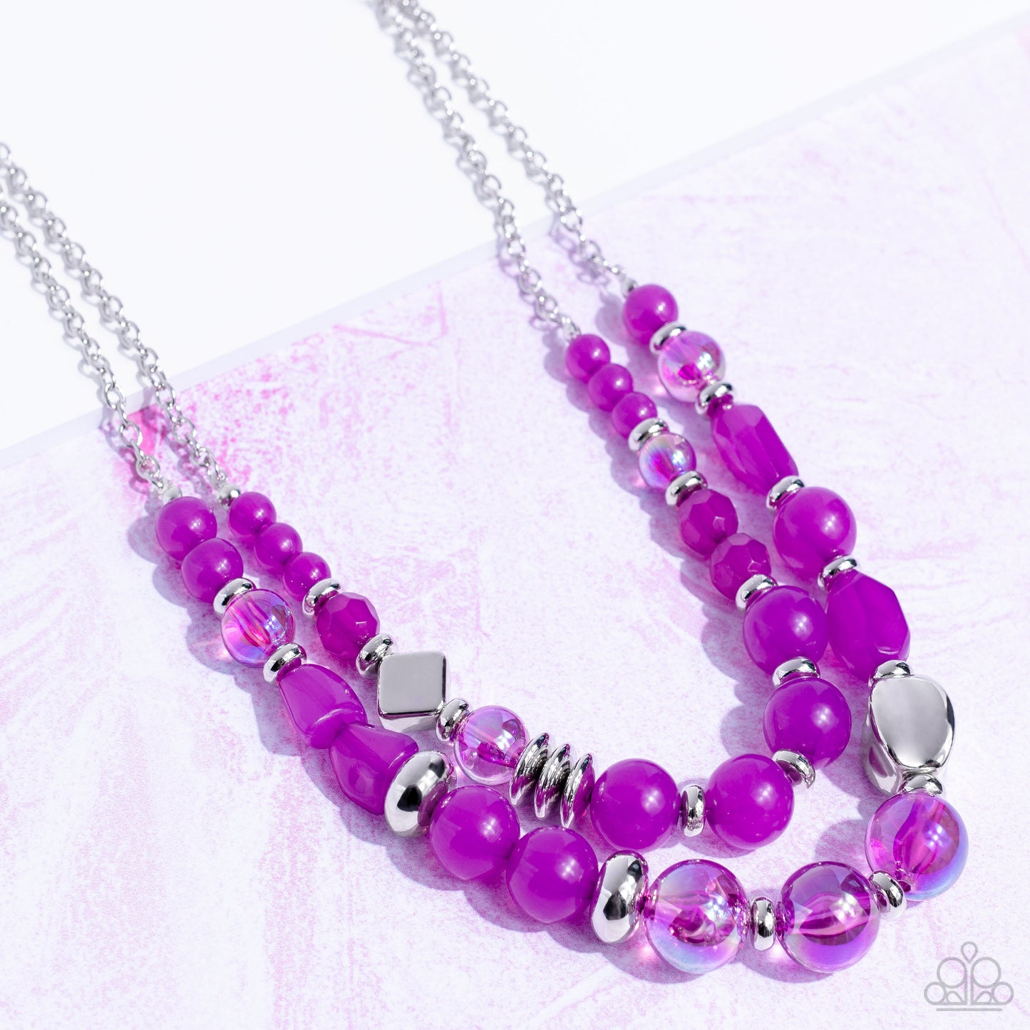 Paparazzi Accessories Mere Magic - Purple Featuring various shapes and finishes, a mismatched assortment of silver, iridescent, and opaque Dahlia beads have been threaded along invisible wires below the collar, creating ethereal layers. Features an adjust