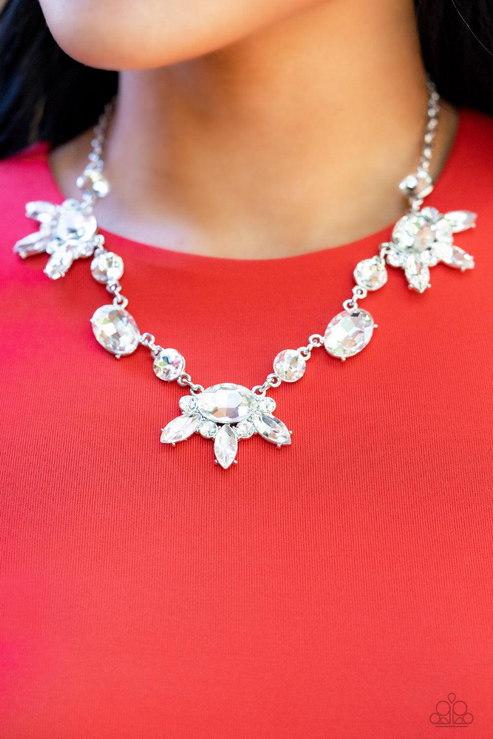 Paparazzi Accessories GLOW-trotting Twinkle - White Brilliant white rhinestones in round, oval, and marquise cuts, create an abstract pattern as they fall along the neckline. The faceted surfaces of each gem catch and reflect light from every angle, resul