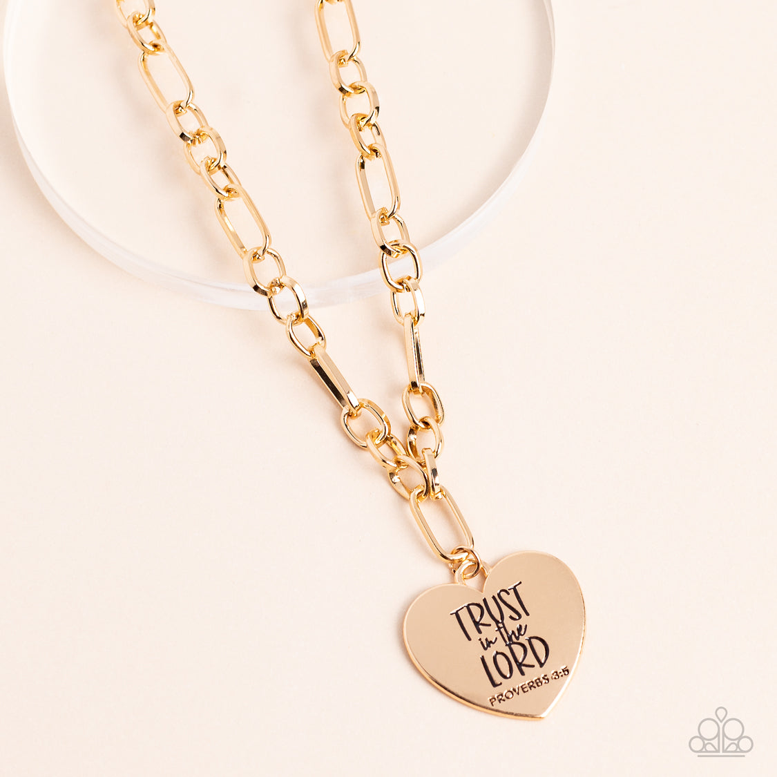 Paparazzi Accessories Perennial Proverbs - Gold Dangling from a gold figaro chain, a charming heart pendant swings. Stamped upon the shiny surface, the phrase "Trust in the Lord" with the bible reference listed below it "Proverbs 3:5" are listed in differ