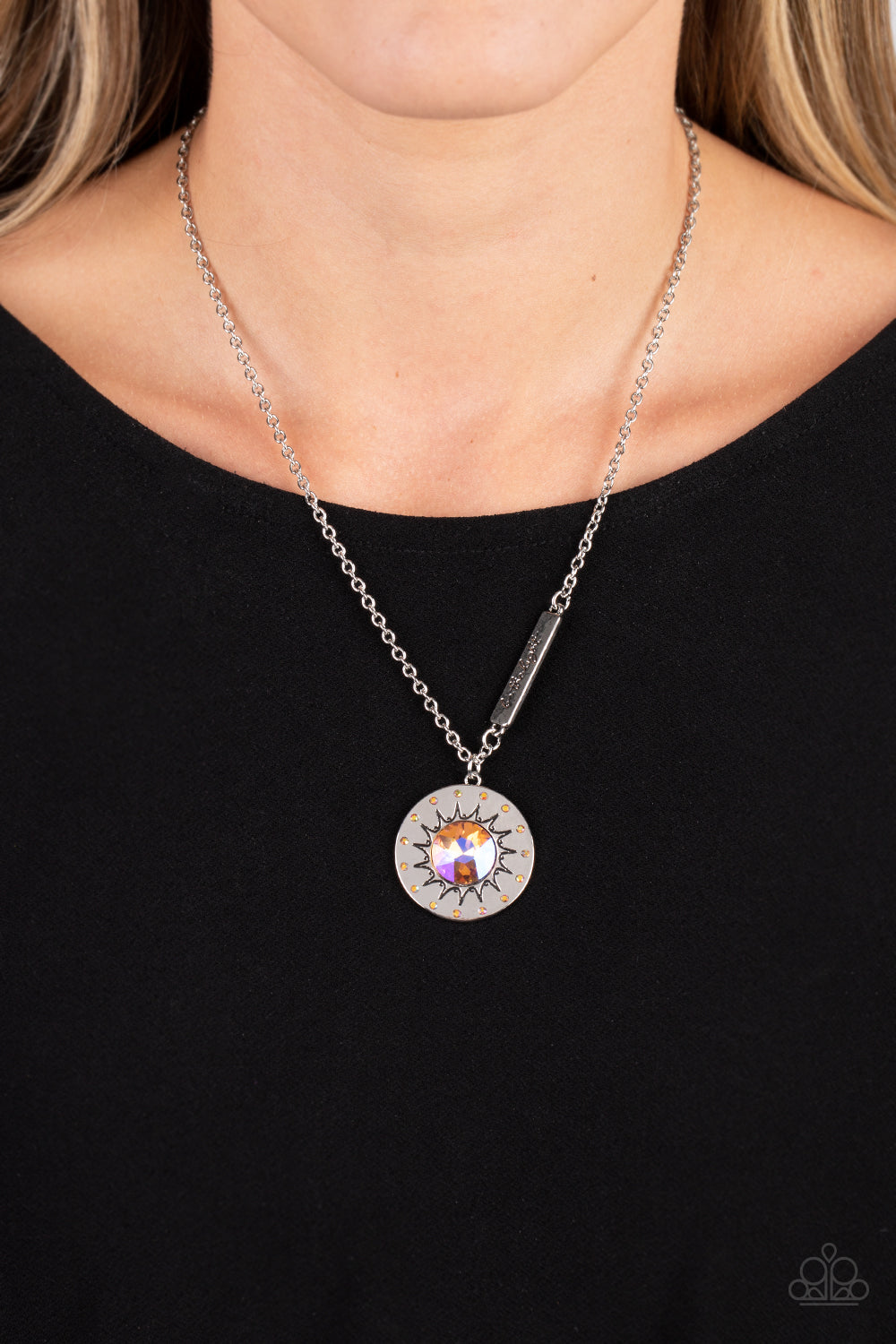 Paparazzi Accessories Sundial Dance - Orange Hanging from the bottom of a classic silver chain, a silver pendant, with a lightly hammered sheen rests. Stamped on the pendant, a sun outlines the center with dainty orange rhinestones outlining the shape. Br