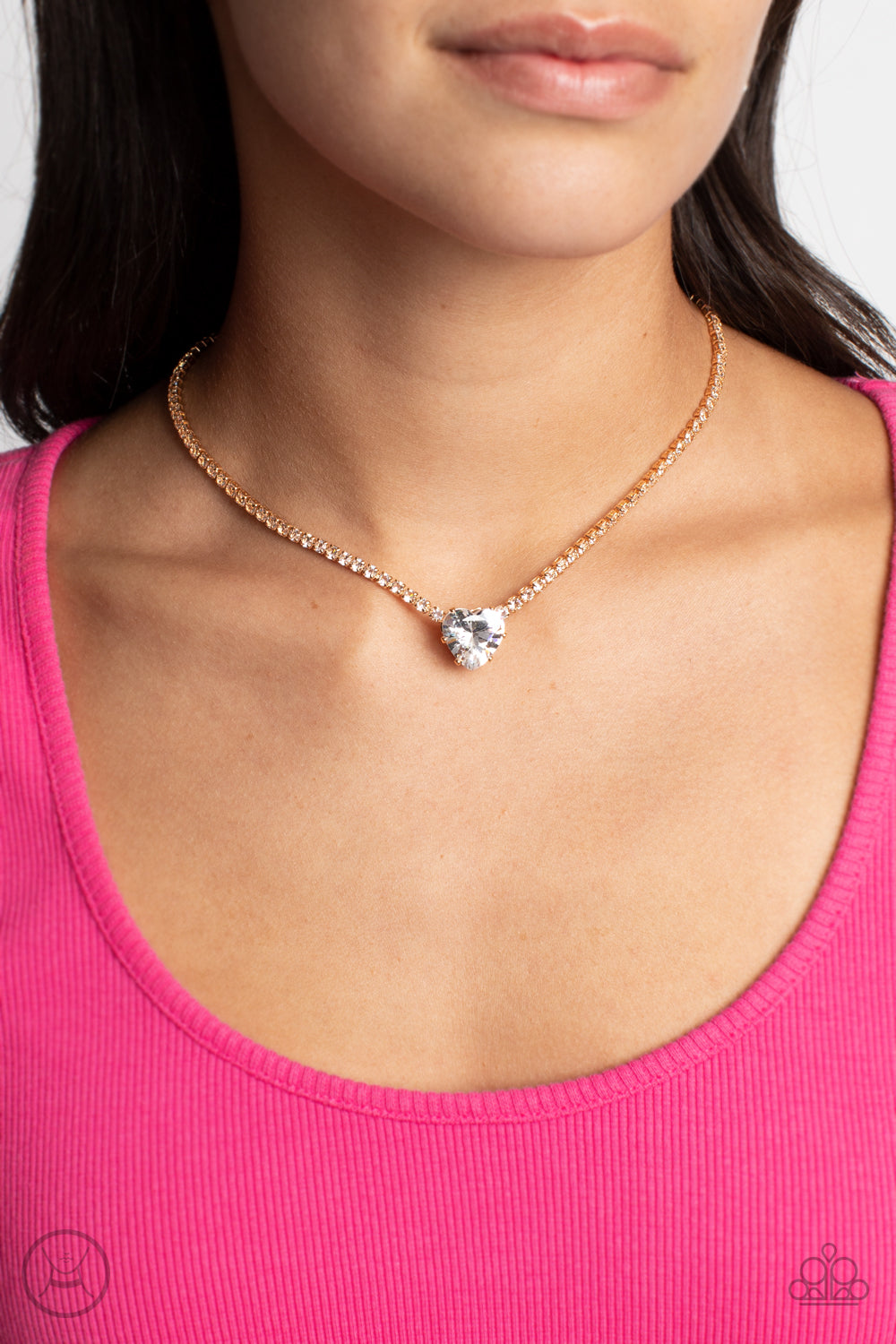 Paparazzi Accessories Flirty Fiancé - Gold An oversized white heart-shaped gem, set in an airy, pronged gold fitting, glitters at the center of a blinding row of dainty, glassy white rhinestones set in square gold fittings, resulting in a flirtatious spar
