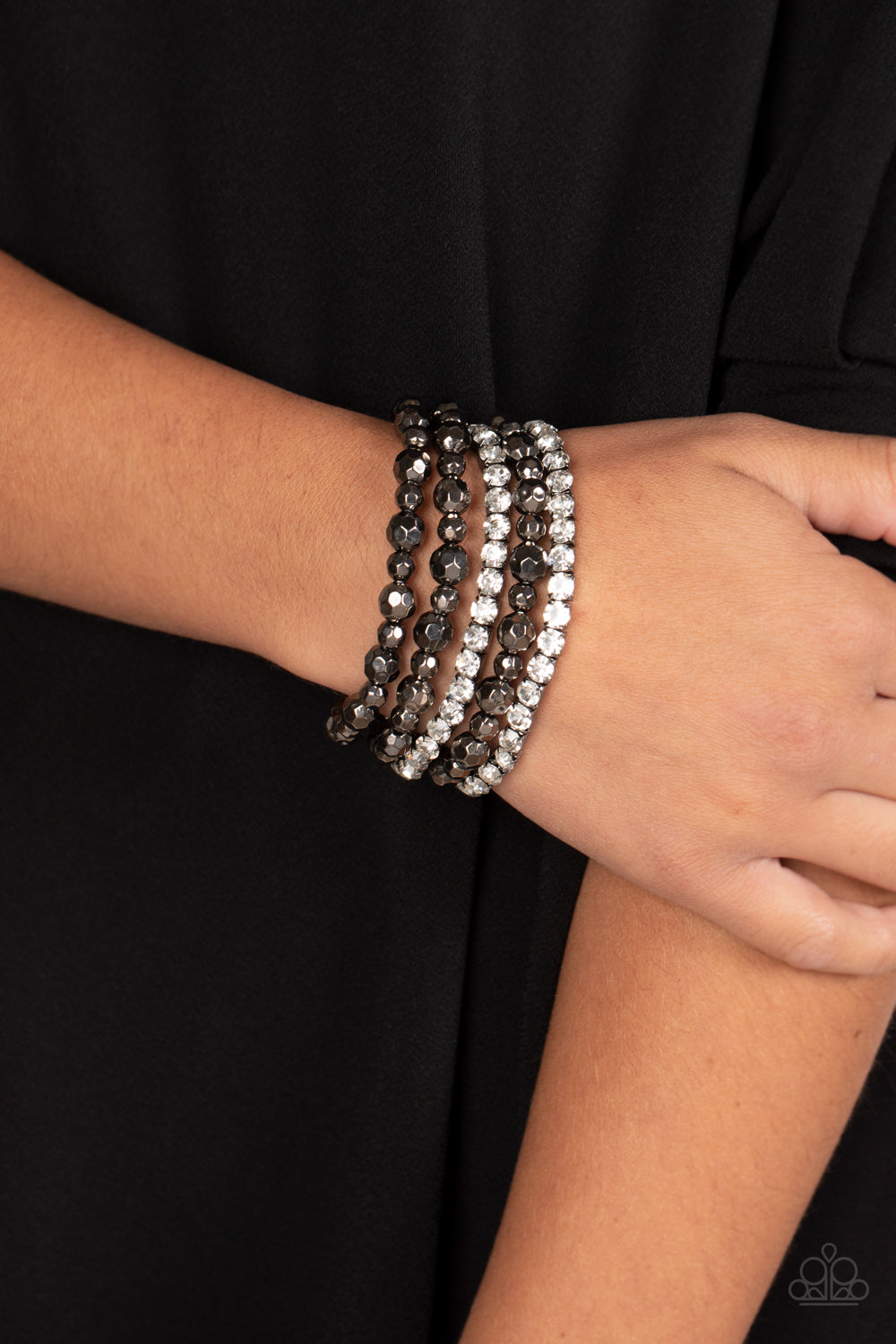 Paparazzi Accessories Top Notch Twinkle - Black Threaded along elastic stretchy bands, varying sizes of faceted gunmetal beads, combine with white gems pressed into gunmetal square fittings for a glamorous, high-sheen stack around the wrist. Sold as one s