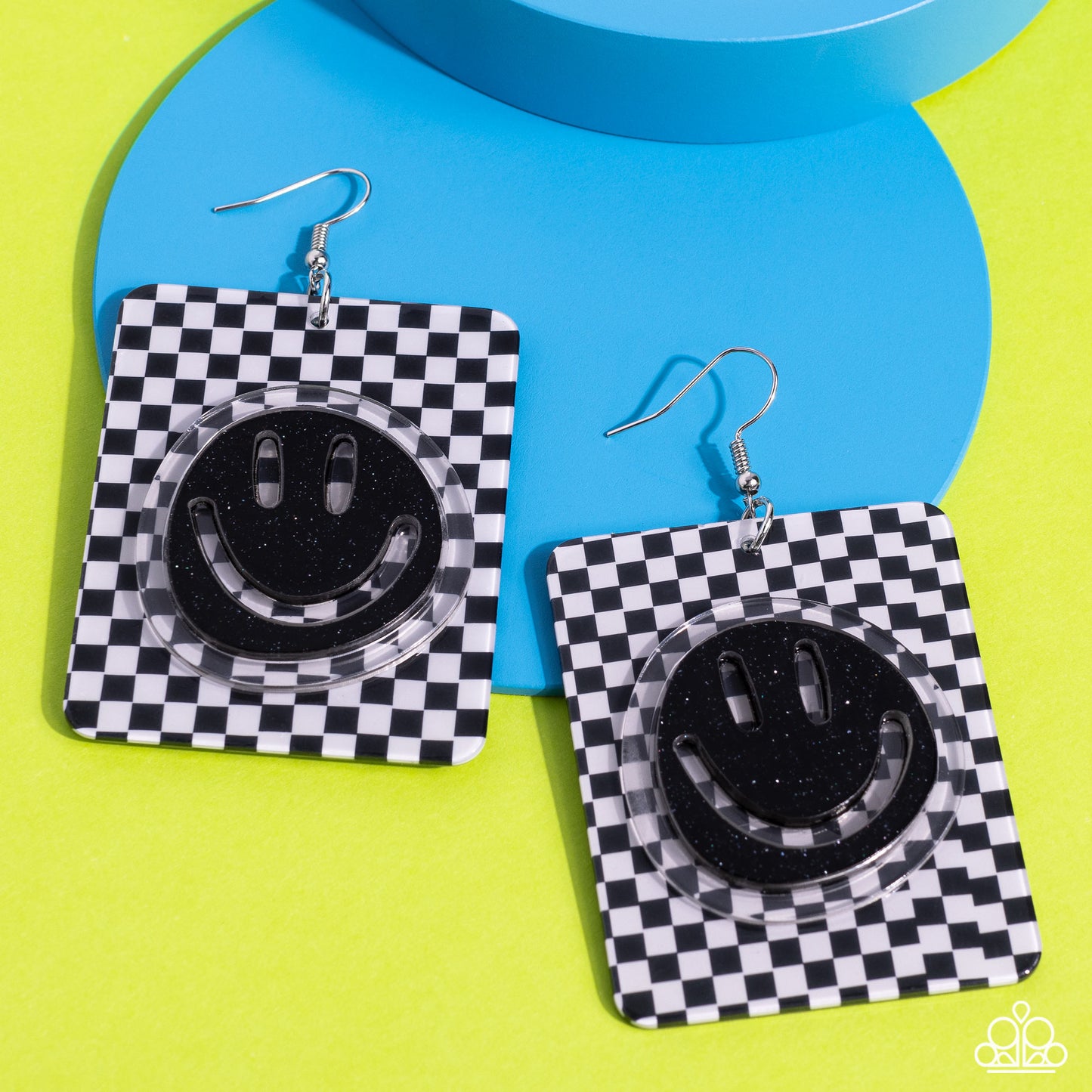 Paparazzi Accessories Cheeky Checkerboard - Black Set against a trendy, checkerboard backdrop, an oversized, sparkly, black smiley face stands out for a cheerfully captivating statement piece near the ear. Earring attaches to a standard fishhook fitting.