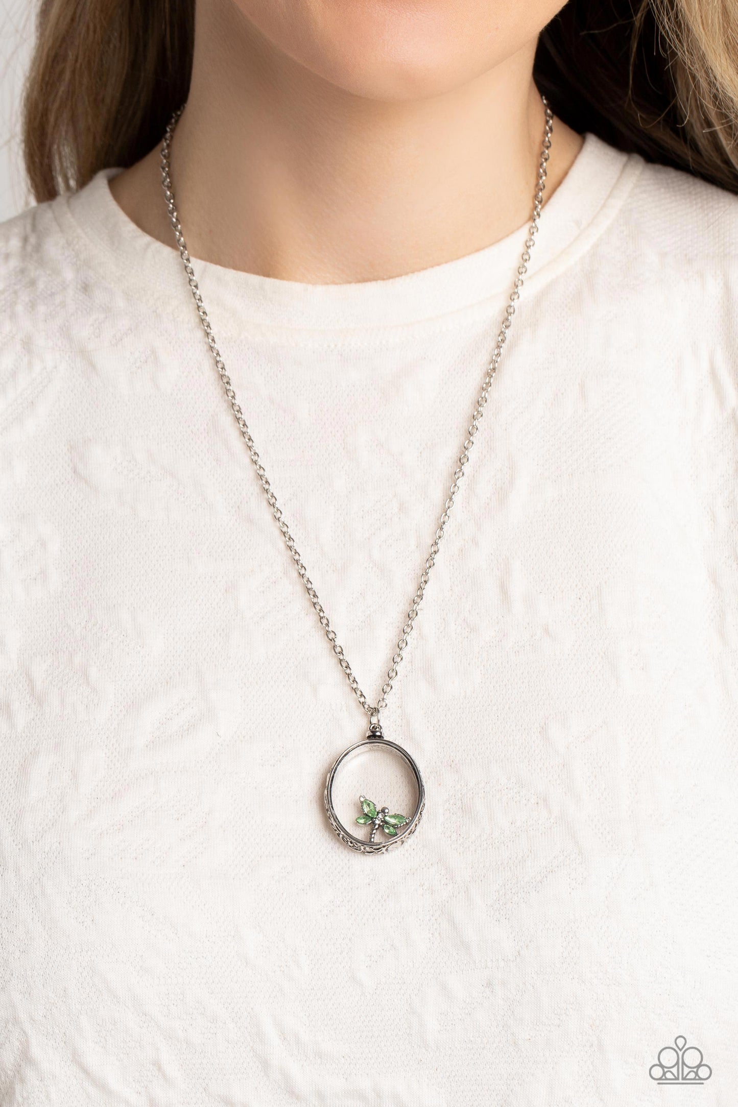 Paparazzi Accessories Dynamic Dragonfly - Green Falling from a high-sheen silver chain, a thick oval pendant with a faceted clear center lengthens the torso as it swings from the bottom of the chain. Swinging from the center of the shimmery pendant, an in