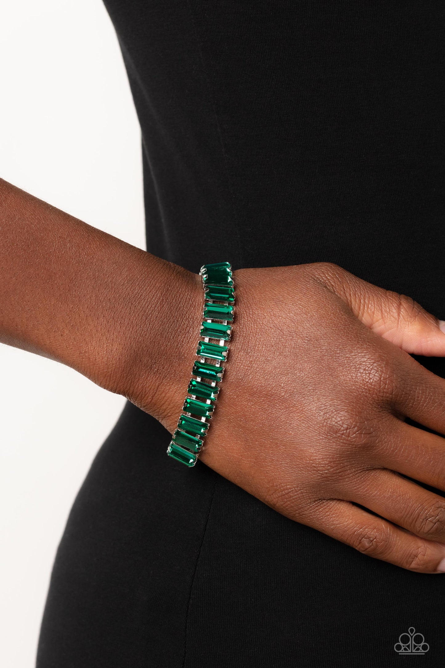 Paparazzi Accessories Darling Debutante - Green Set in prominent, pronged silver fittings, a glassy collection of emerald-cut, green gems fall in line around the wrist, creating a stunning, light-catching display. Features an adjustable clasp closure. Sol