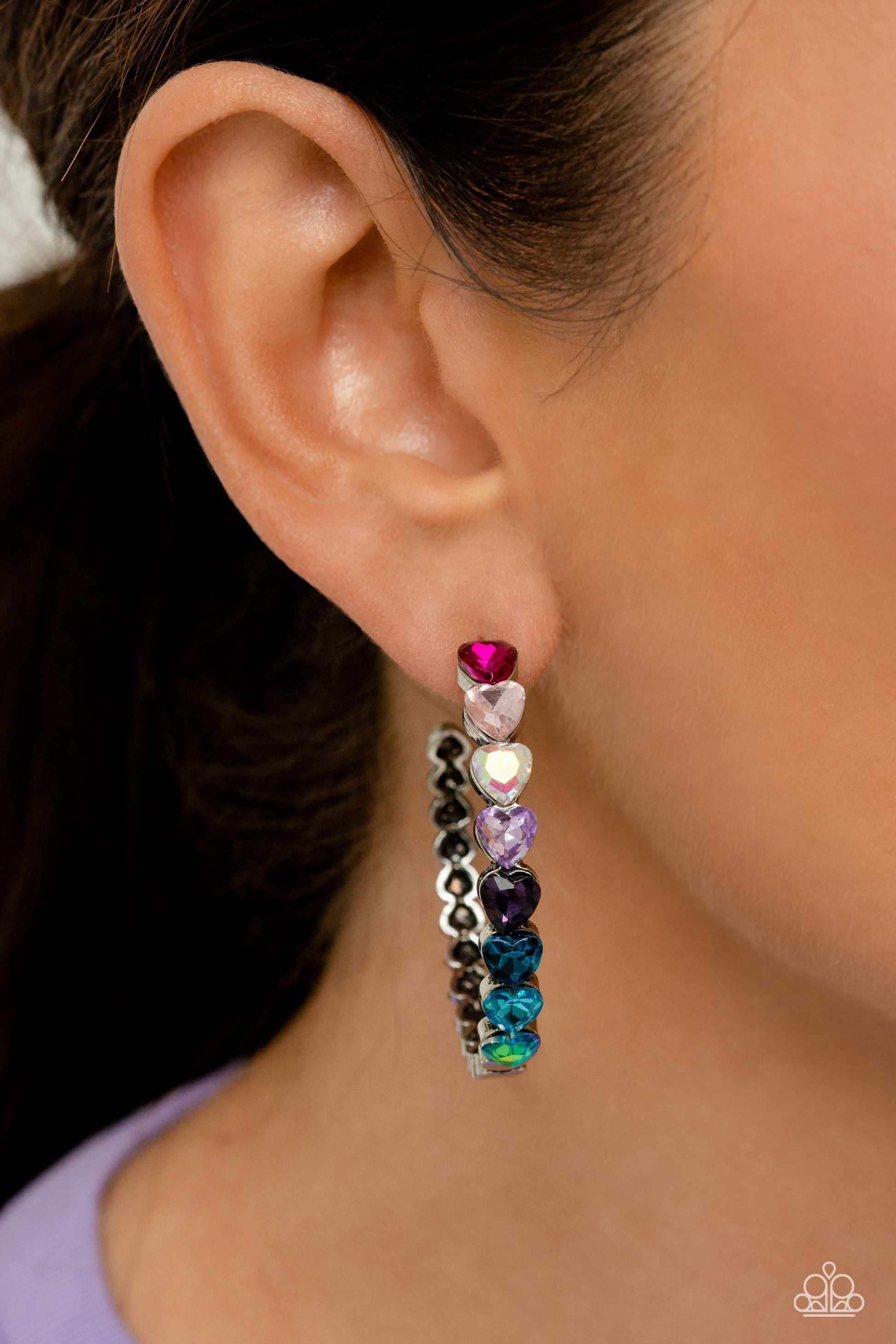 Paparazzi Accessories Hypnotic Heart Attack - Multi Featuring a scalloped heart frame, glittery heart rhinestones in shades of pink, iridescence, purple, blue, and a refracted green shimmer slowly decrease in size as they curve down the ear to meet dainty