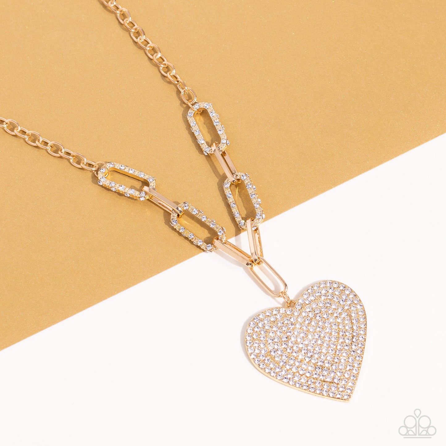 Paparazzi Accessories Roadside Romance - Gold Elongated, oversized gold links, encrusted with a blinding display of white rhinestones and shimmery gold accents connect a classic gold chain to an exaggerated gold heart pendant for a romantically refined fi