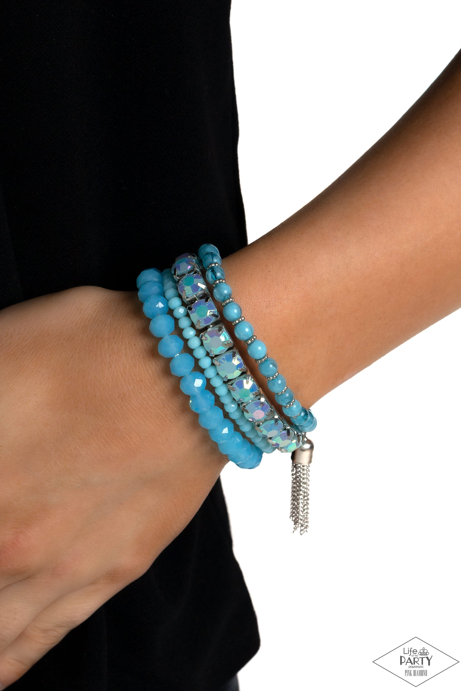 Paparazzi Accessories Day Trip Trinket - Blue Pinched in silver fittings, a band of UV shimmery Waterspout beads joins mismatched strands of smoky, glassy, and faceted blue beads creating four stretchy bracelets around the wrist. A single silver chain tas