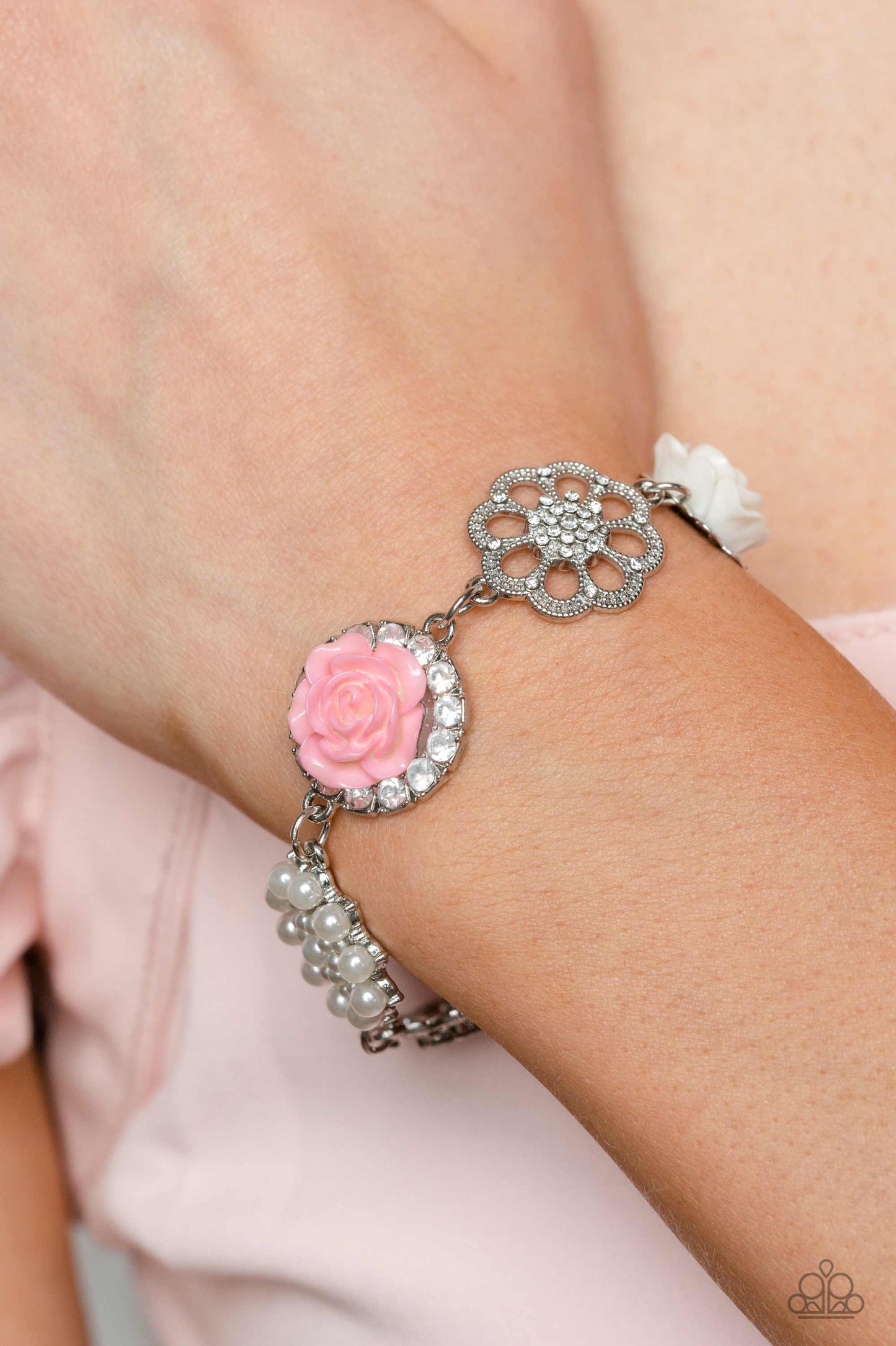 Paparazzi Accessories Tea Party Theme - Pink A collection of whimsical, refined flowers gathers along a flat, sleek silver link chain. The featured charms include an ivory resin rose blooming atop a glittery silver floral silhouette, two silver flowers du